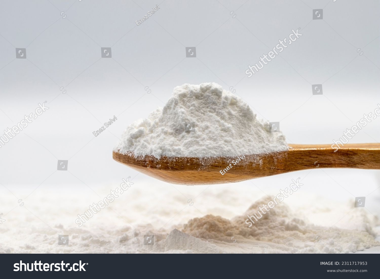 Powdered sugar on wooden spoon. Powdered sugar or icing sugar isolated on white background #2311717953