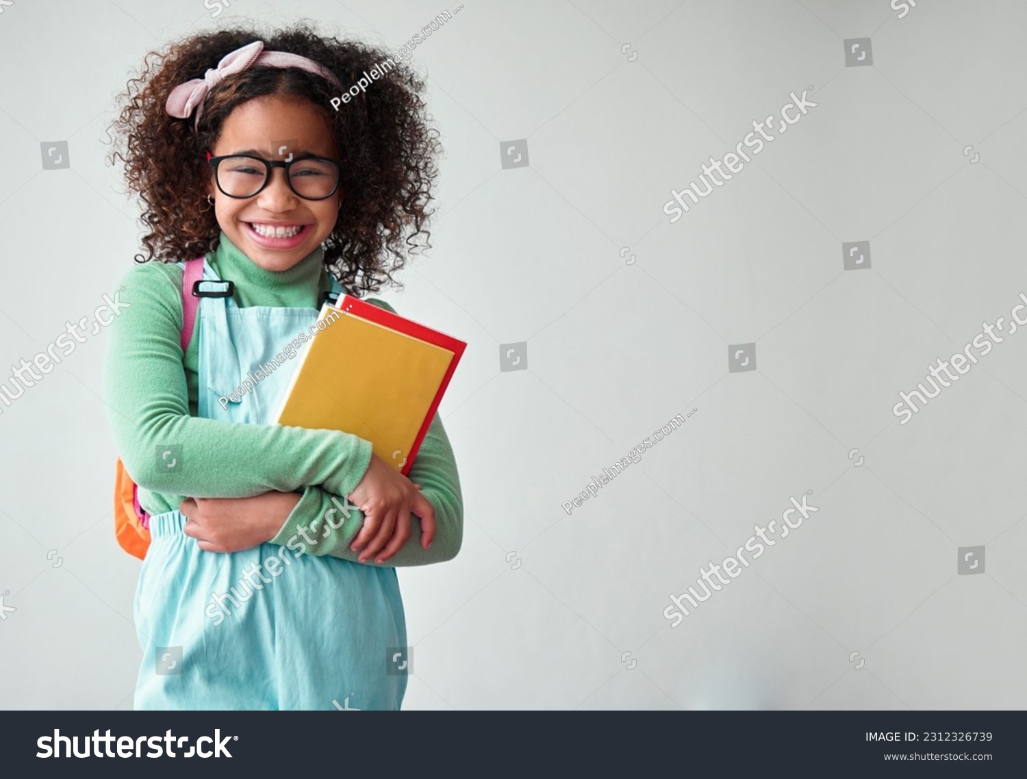 School, portrait of child student with books for knowledge, education and studying in a studio. Happy, smile and young smart girl kid with glasses for reading by a white background with mockup space. #2312326739