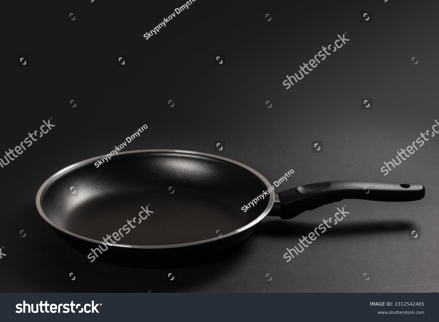Black fry pan on dark background. close up. #2312542465