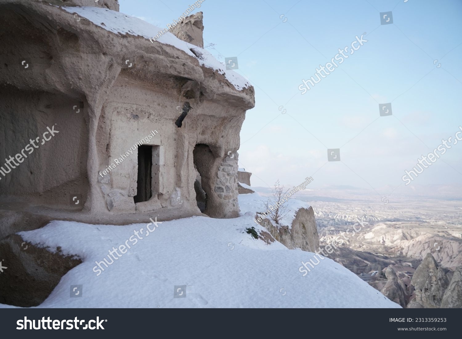 snowy hill cave houses in Uchisar city, Cappadocia, Turkey #2313359253