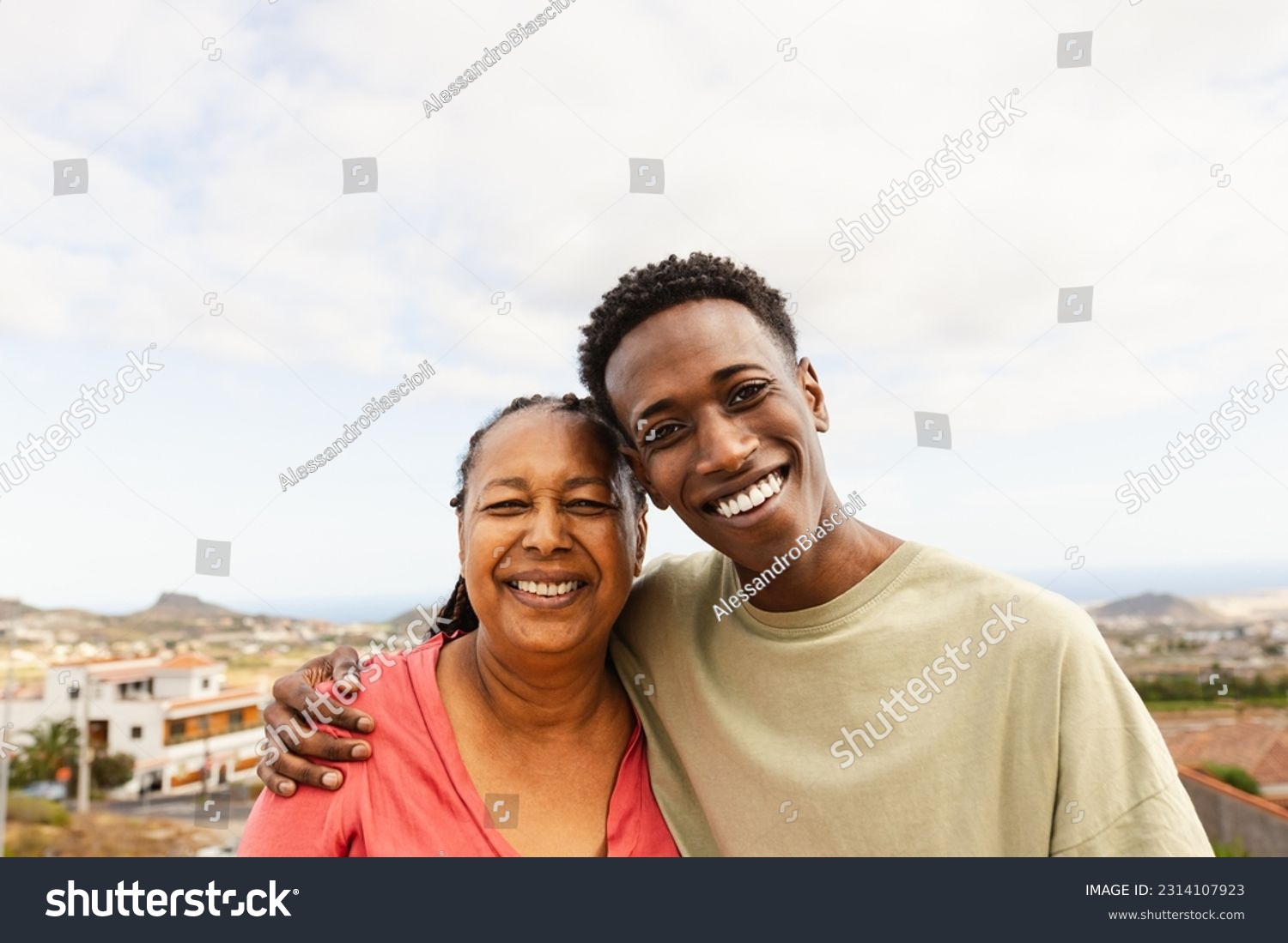 Happy African grandson hugging her grandmother at house rooftop #2314107923