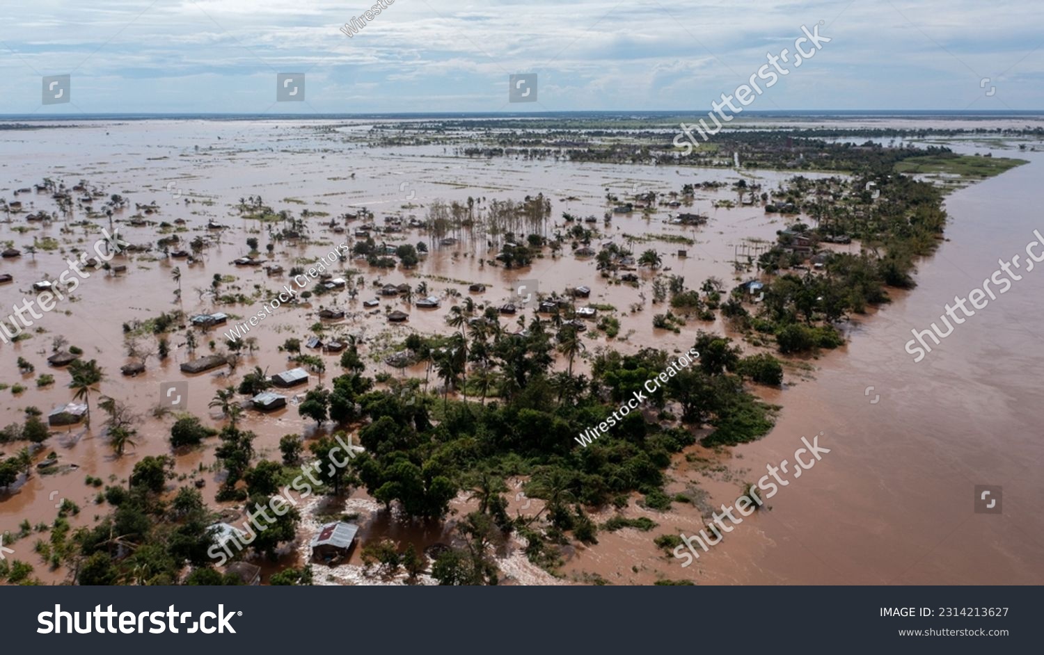 A big flood with trees and a village in the dirty waters in Africa #2314213627
