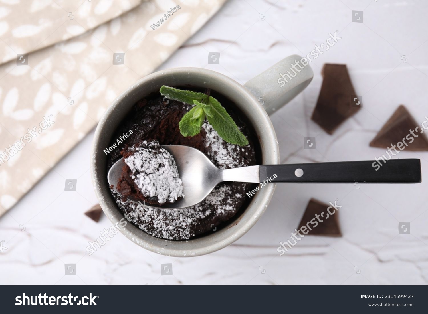 Tasty chocolate mug pie with mint and spoon on white textured table, flat lay. Microwave cake recipe #2314599427