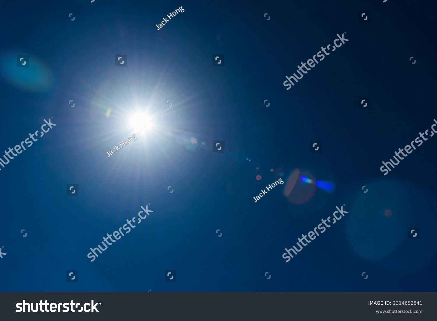 Close-up of flare spots from the sun's rays with the clear blue sky background. #2314652841