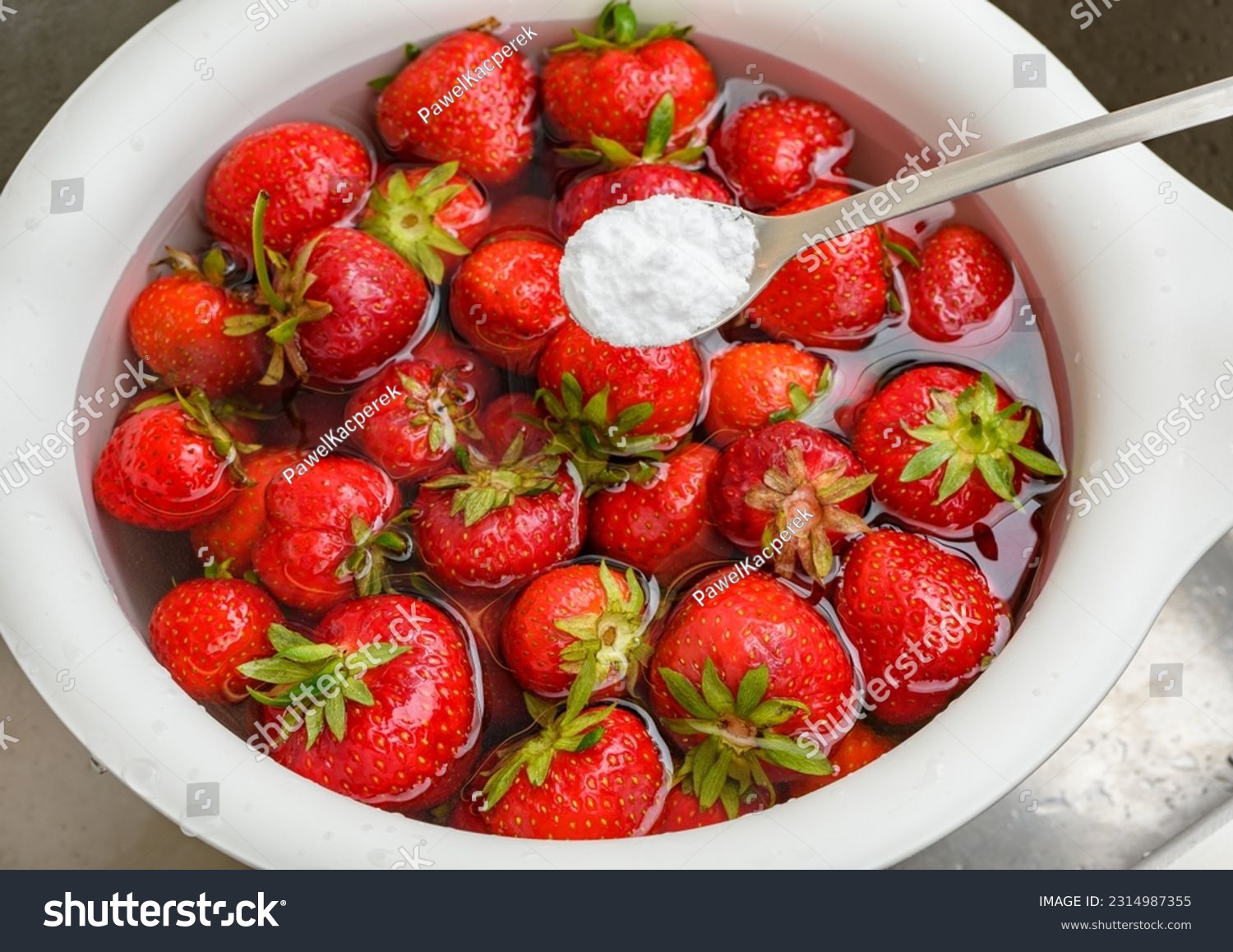 Rinsing fresh strawberry fruit in water with the addition of baking soda #2314987355