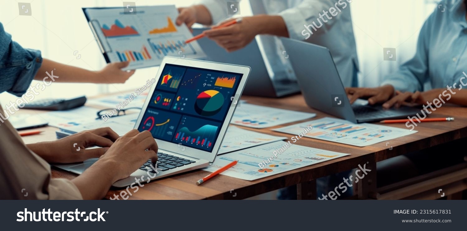 Panorama shot analyst team utilizing BI Fintech to analyze financial report with laptop. Businesspeople analyzing BI power dashboard displayed on laptop screen for business insight. Scrutinize #2315617831