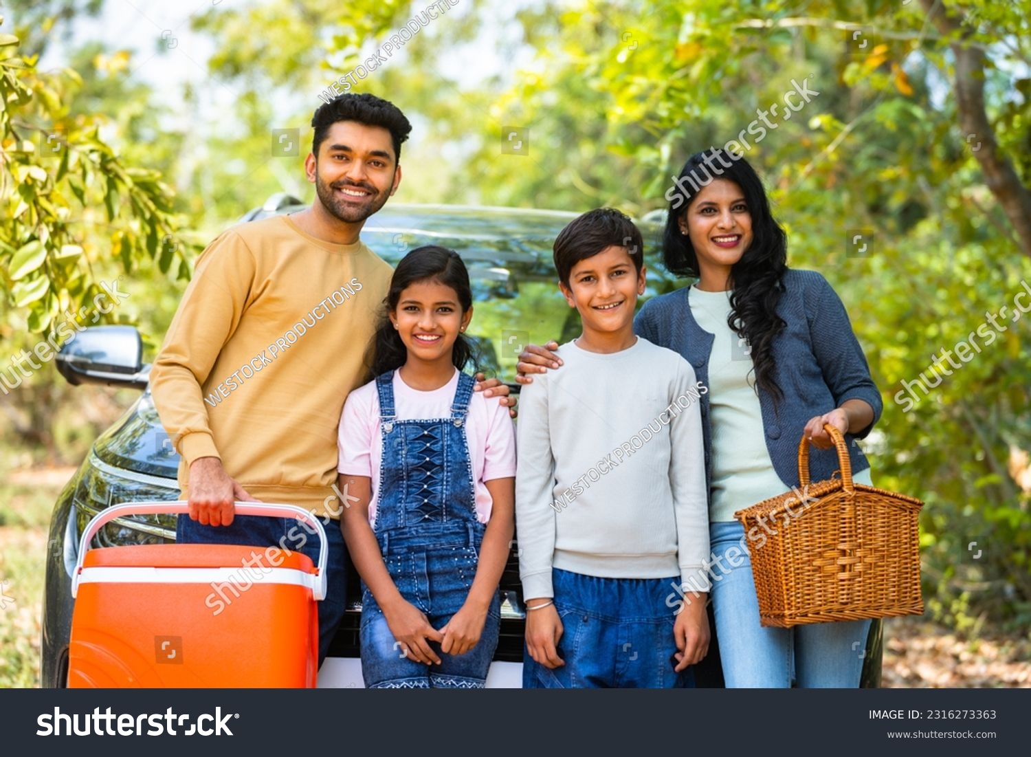 Happy smiling family with sibling kids standing in front of car for picnic by looking camera during holiday travel - concept of joyful lifestyle, family time and freedom #2316273363