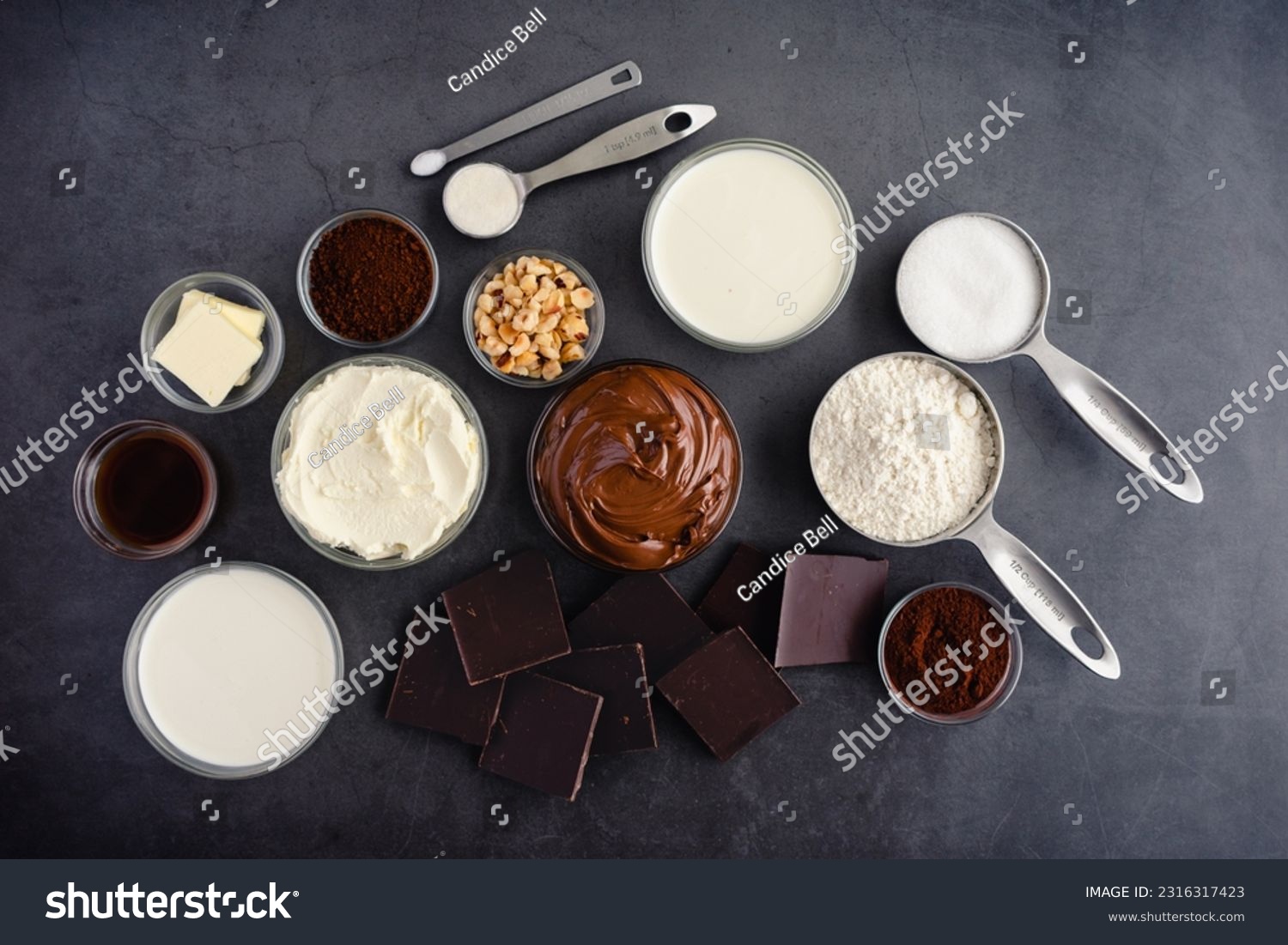 Chocolate Hazelnut Mousse Cake Ingredients on a Dark Background: Hazelnut spread, dark chocolate, cream, and other cake ingredients #2316317423