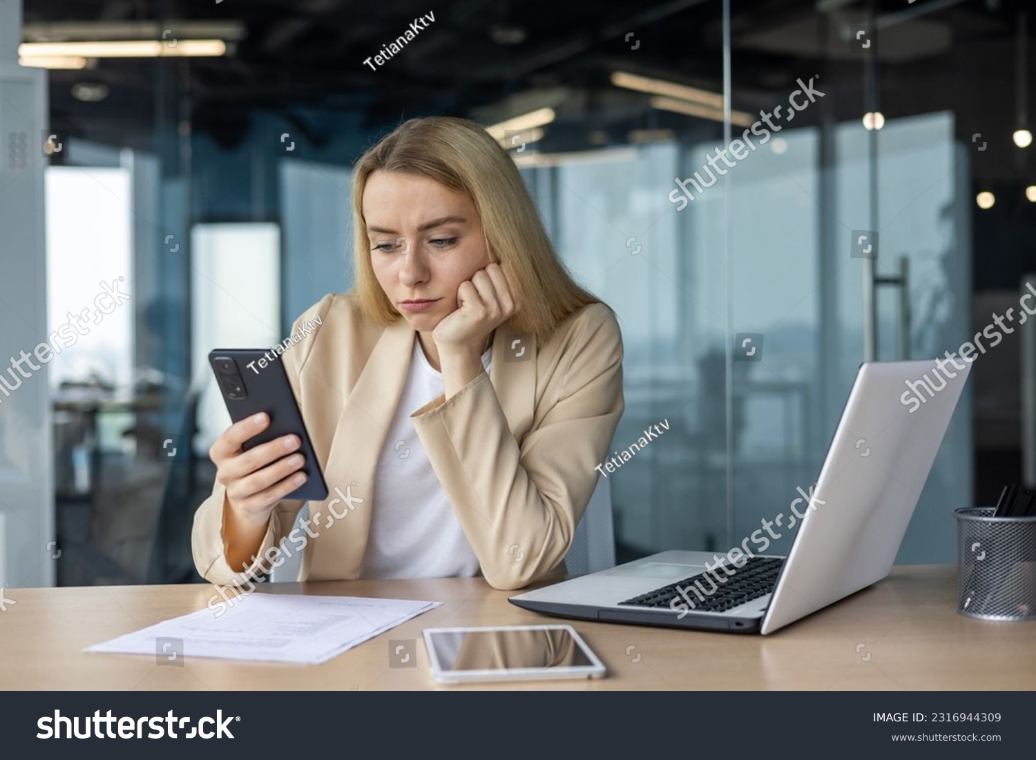 Sad and disappointed woman received bad news online, business woman at workplace inside office in depression reading bad news using app on smartphone, female worker with phone in hands thoughtful. #2316944309