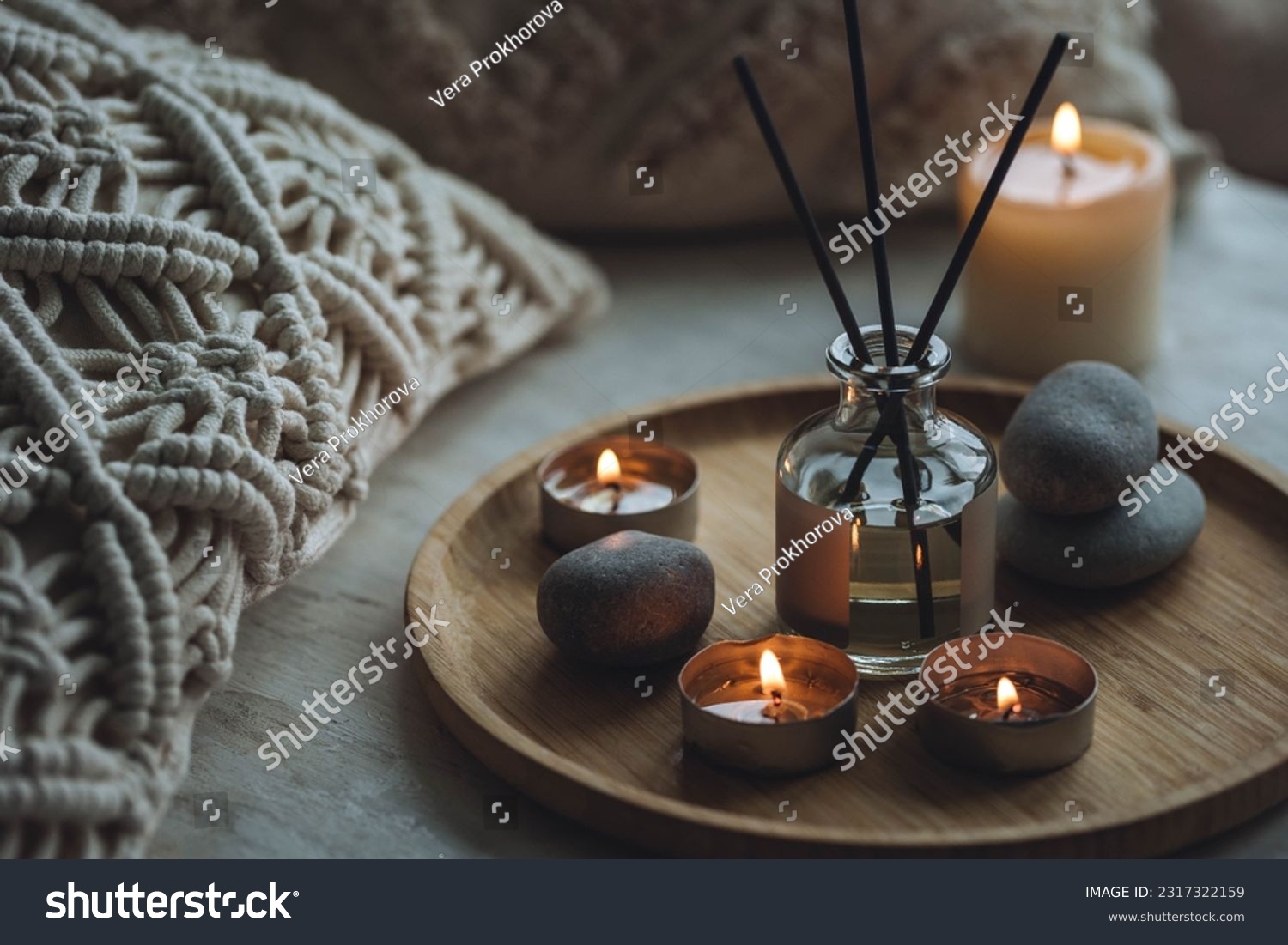 Apartment natural aroma diffusor with sea breeze fragrance. Burning candles on bamboo tray, cozy home atmosphere. Relaxation, detention zone in the living or bedroom. Stones as decor #2317322159
