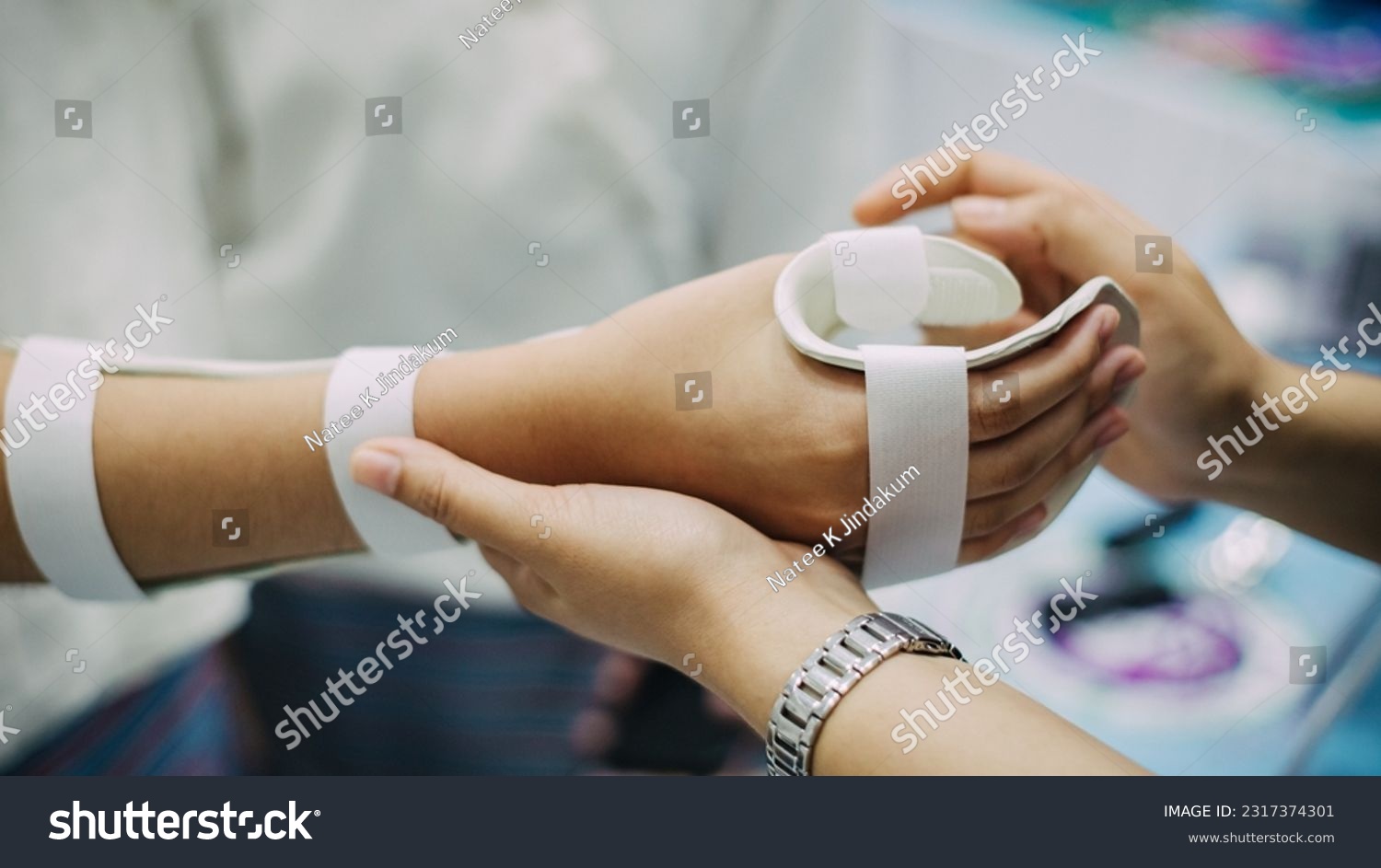 Therapist making asissistive device for immobilize patient hand. Splint service for hand injury rehabilitation of occupational therapy clinic. #2317374301
