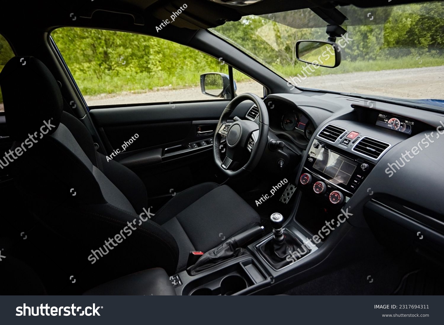 Dark car interior - steering wheel, shift lever and dashboard. Car modern  inside. Side view  #2317694311