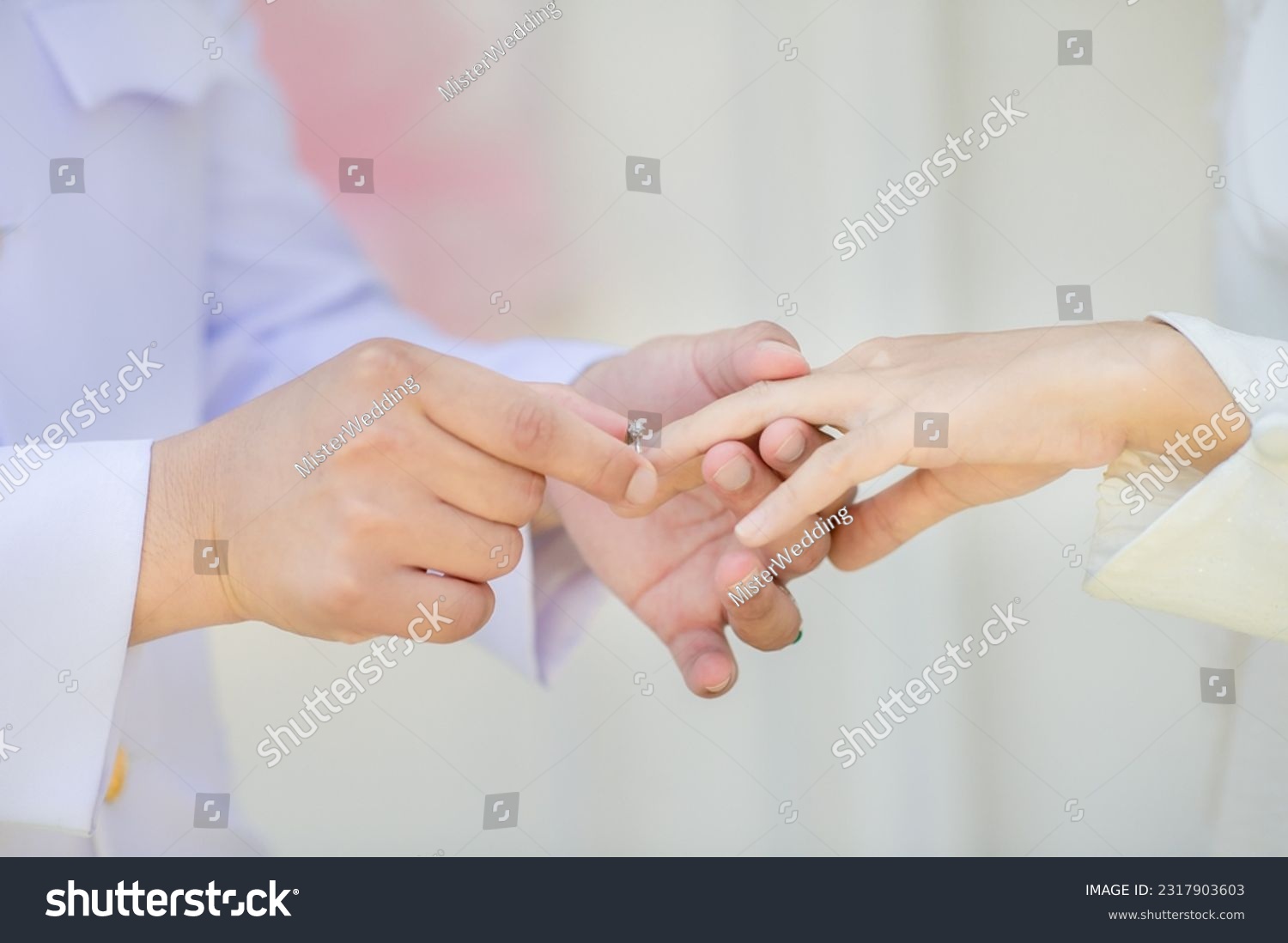 muslim groom in white dress wear wedding rings to left ring finger of muslim bride.concept for wedding card background, poster,Invitation card #2317903603
