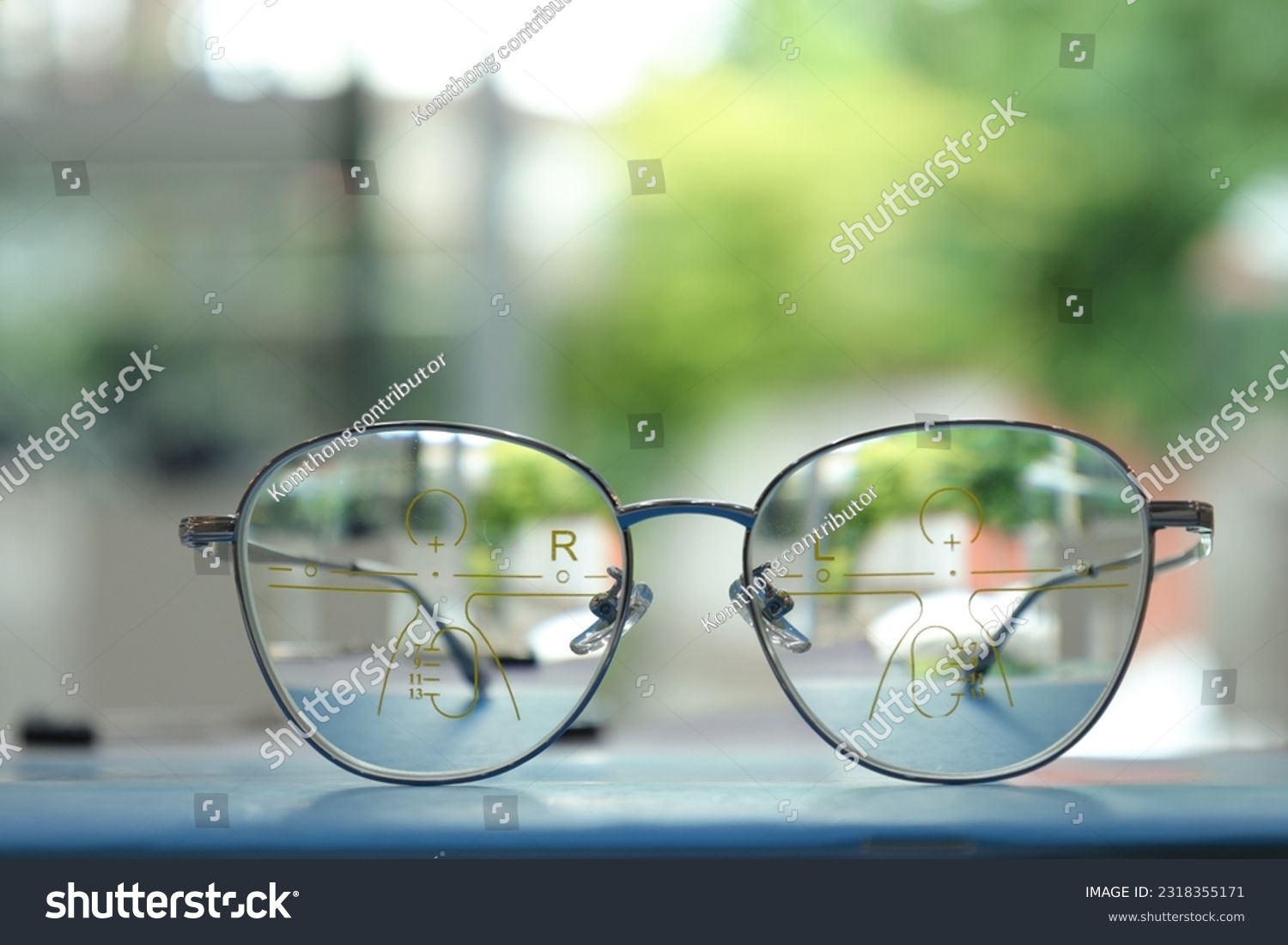 Eyeglasses on table, progressive lenses, eyeglasses for the elderly, glasses progressive lens, eyeglass progressive lens, close-up of glasses on lenses test, looking through glasses #2318355171