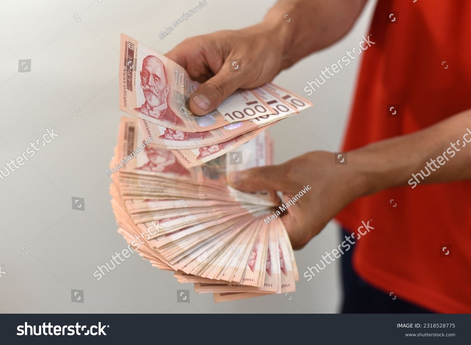 Hands holding pile of money. Serbian dinar paper currency, 1000 dinars value #2318528775