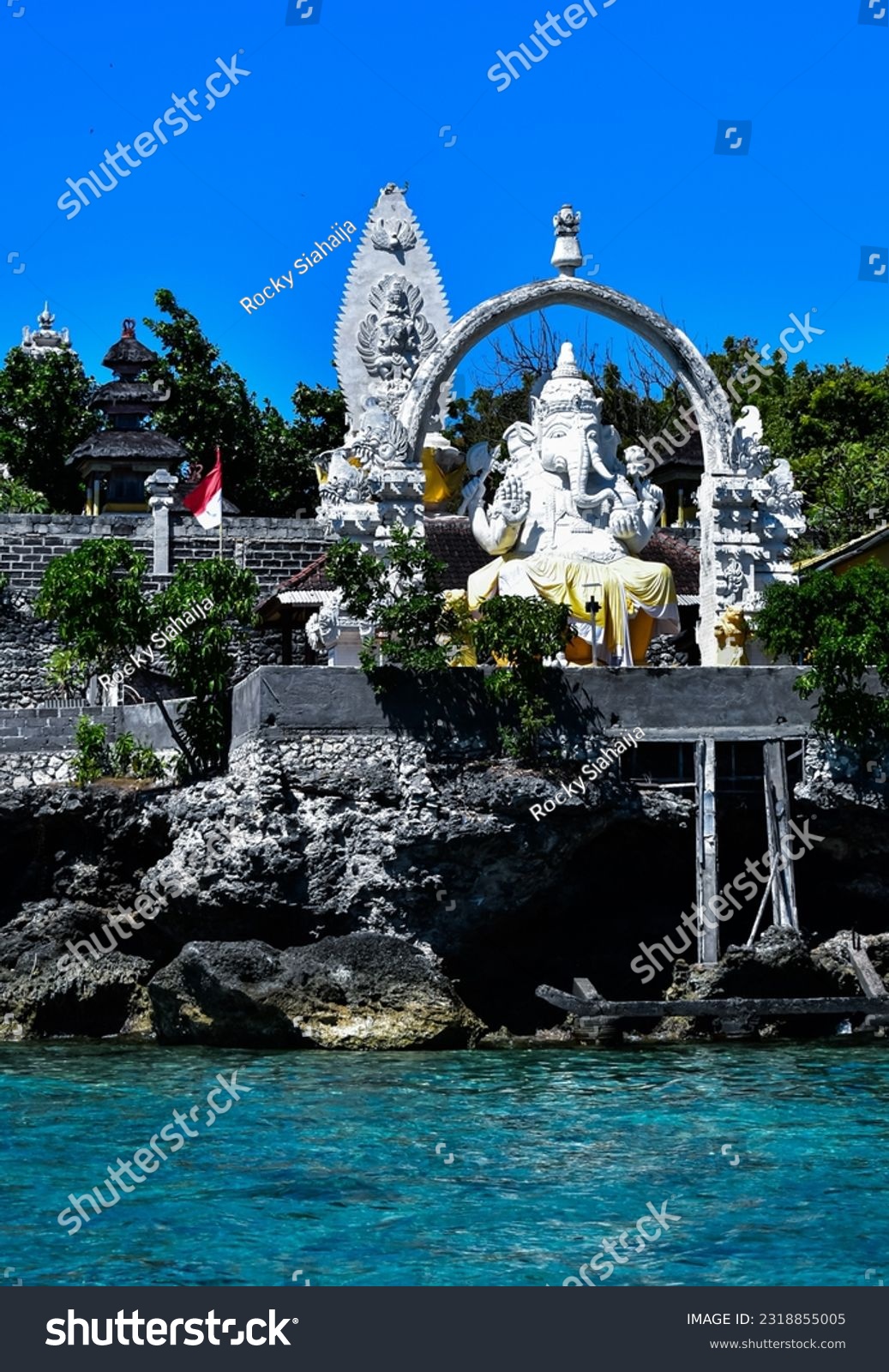 Ganesha statue at Menjangan island temple, West Bali, Indonesia. Blue sea water as foreground, clear blue sky as background  #2318855005