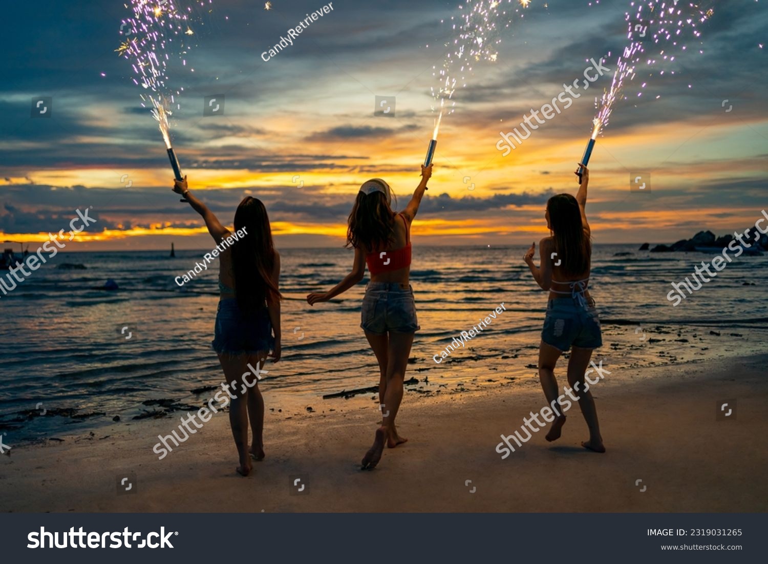 Group of Young Asian woman friends playing sparklers firework together at tropical island beach in summer night. Attractive girl enjoy and fun outdoor lifestyle beach party on holiday travel vacation. #2319031265