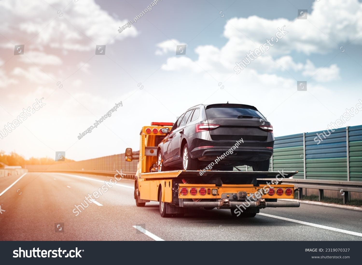 Reliable Towing and Recovery Services: 24-7 Assistance for Vehicle Breakdowns and Accidents. Emergency roadside assistance on the highway. side view of the flatbed tow truck with a damaged vehicle #2319070327