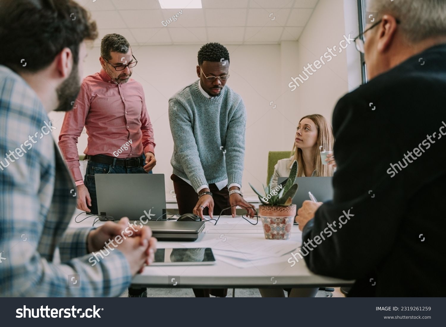 Work employee trying to get everyone’s attention and show them something on the table at the office #2319261259