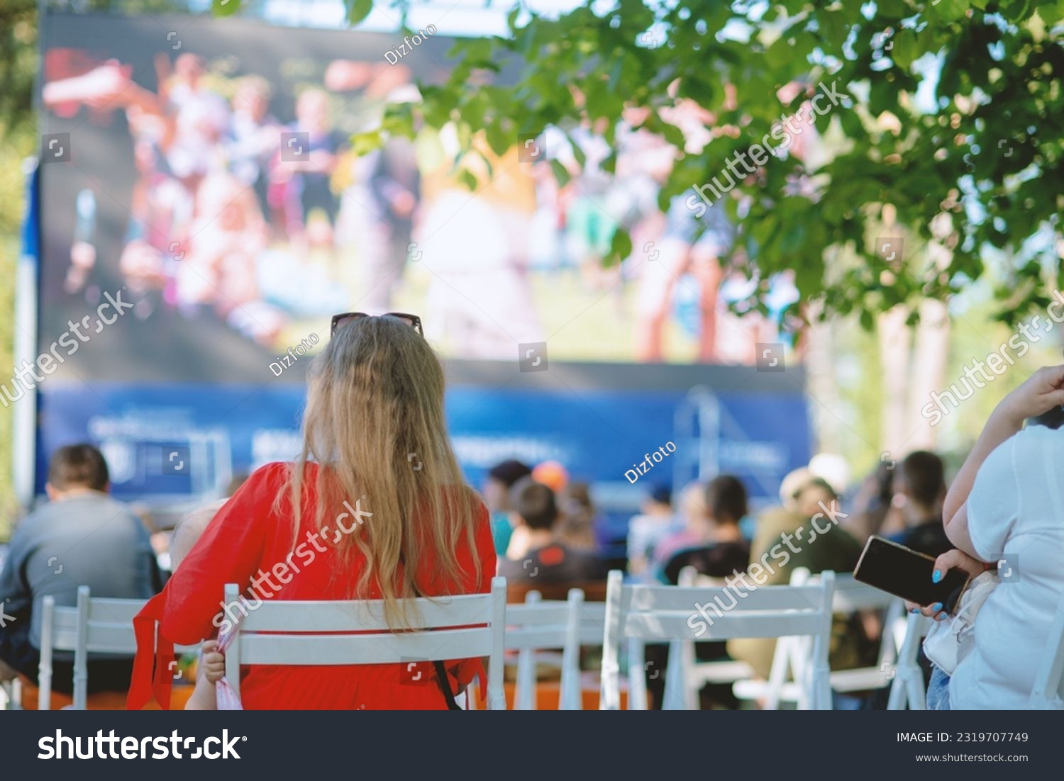 People sit in a summer open-air cinema #2319707749