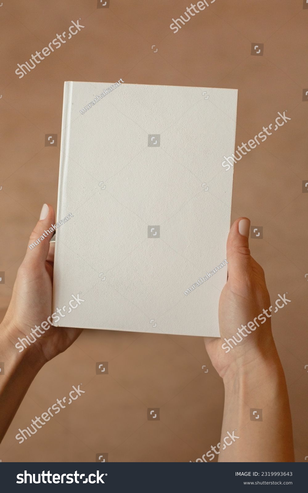 She is holding an empty notebook or book. Mockup book. Blank notebook, blank book #2319993643