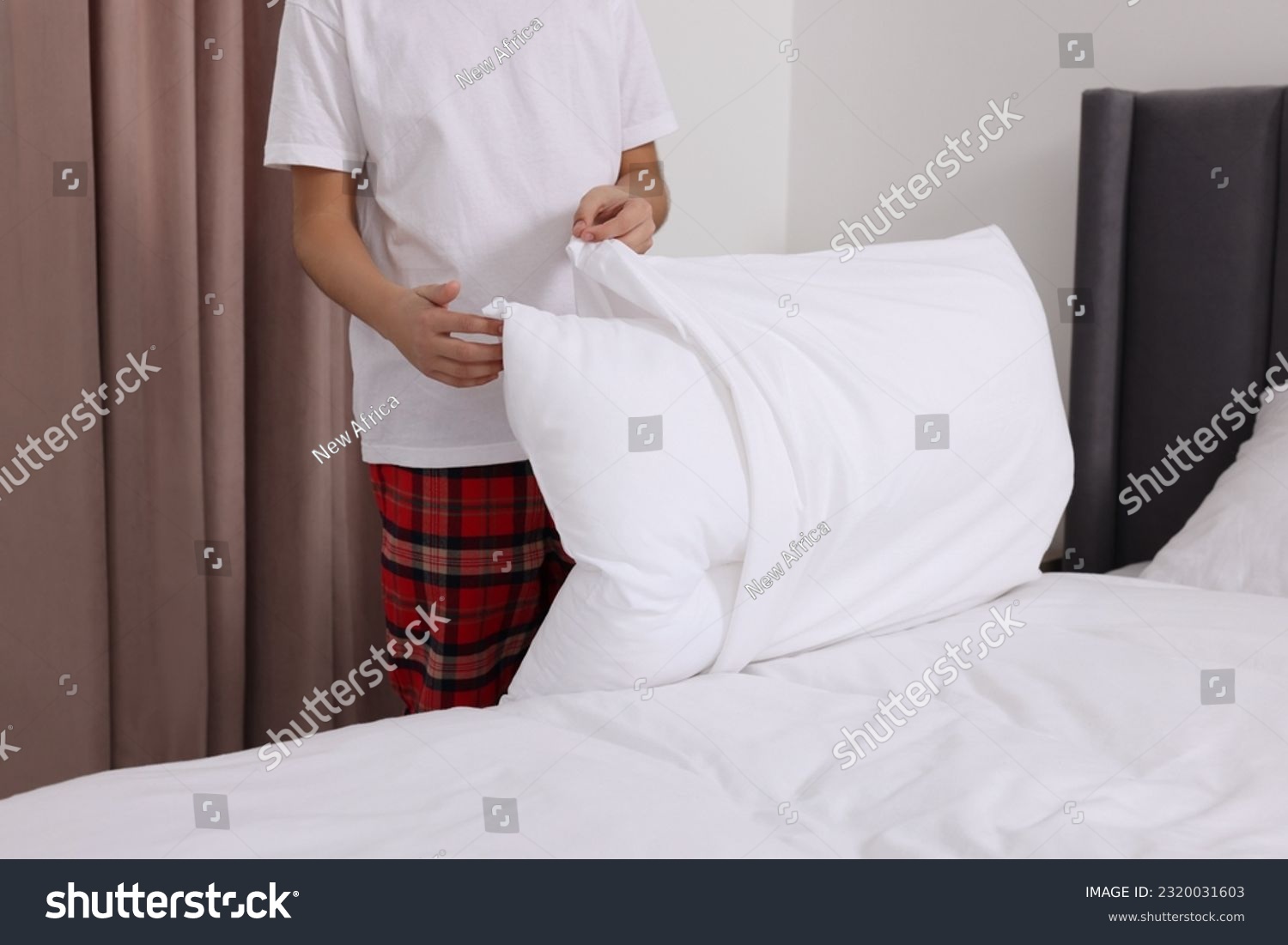 Boy changing pillowcase in bedroom, closeup. Domestic chores #2320031603