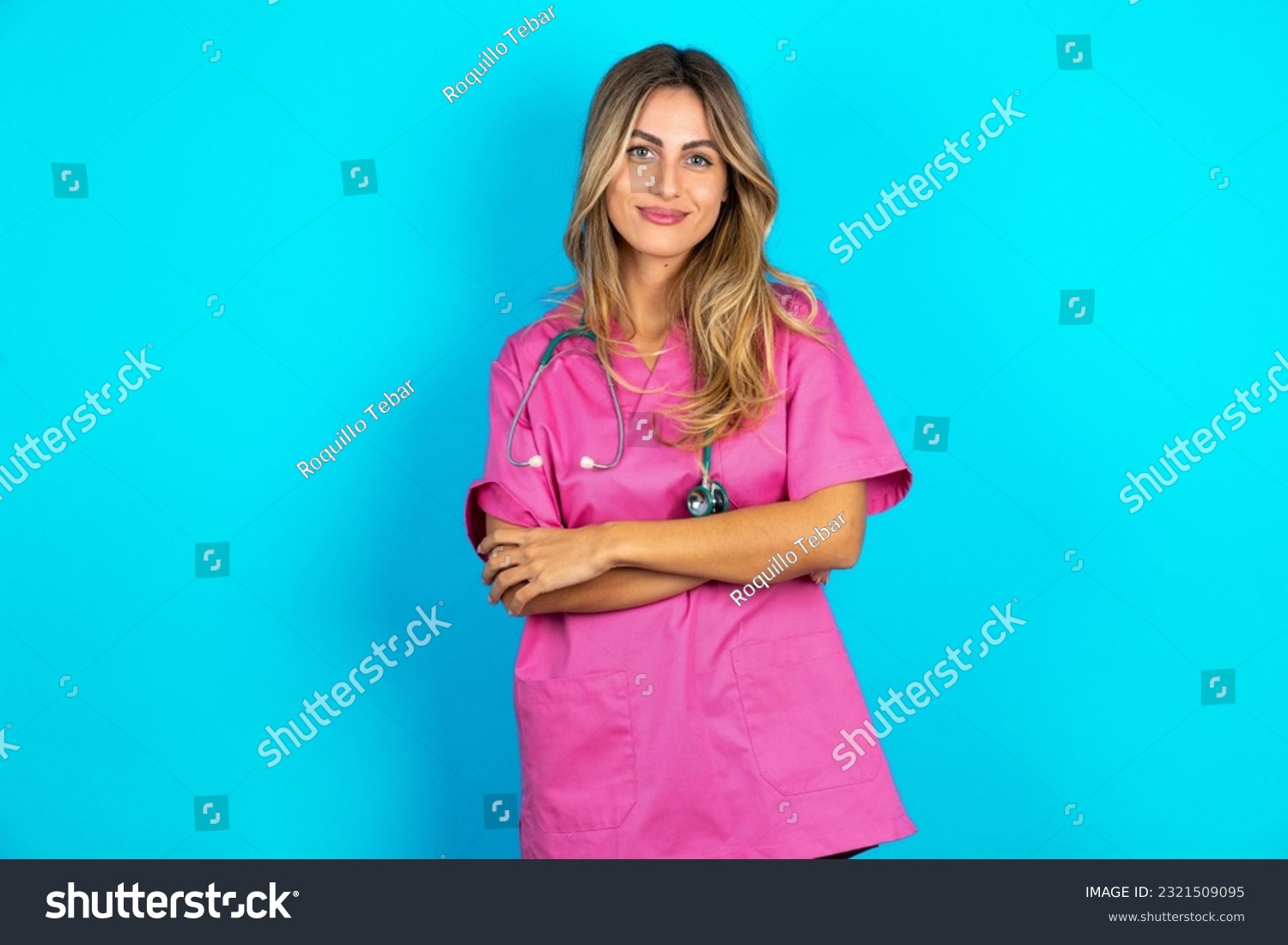 Self confident serious calm young beautiful doctor woman stands with arms folded. Shows professional vibe stands in assertive pose. #2321509095