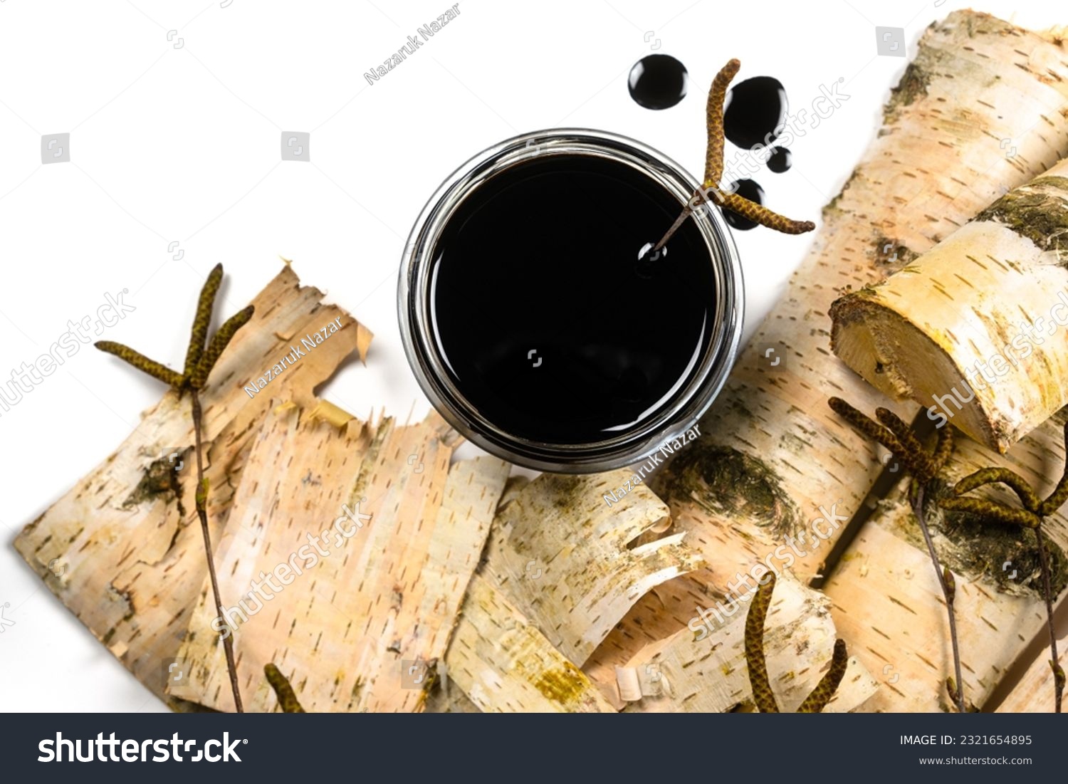 Birch tar or pitch in a jar and birch tree bark on white background. Wood tar. Liquid mineral tar from birch bark #2321654895