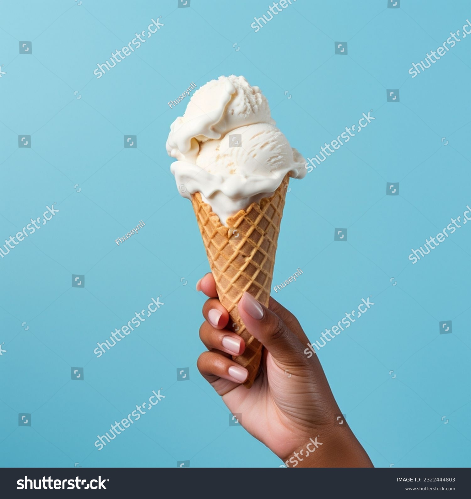 Ice cream cone on a blue background. The woman holding the ice cream by hand.
 #2322444803