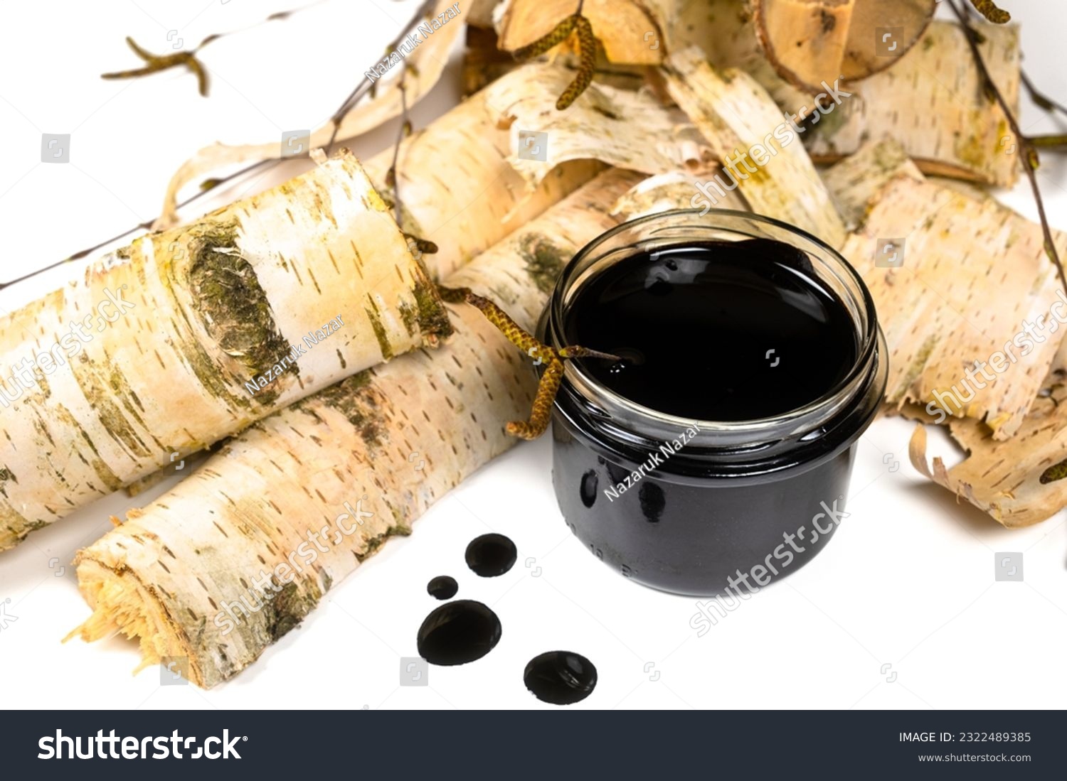 Birch tar or pitch in a jar and birch tree bark on white background. Wood tar. Liquid mineral tar from birch bark #2322489385