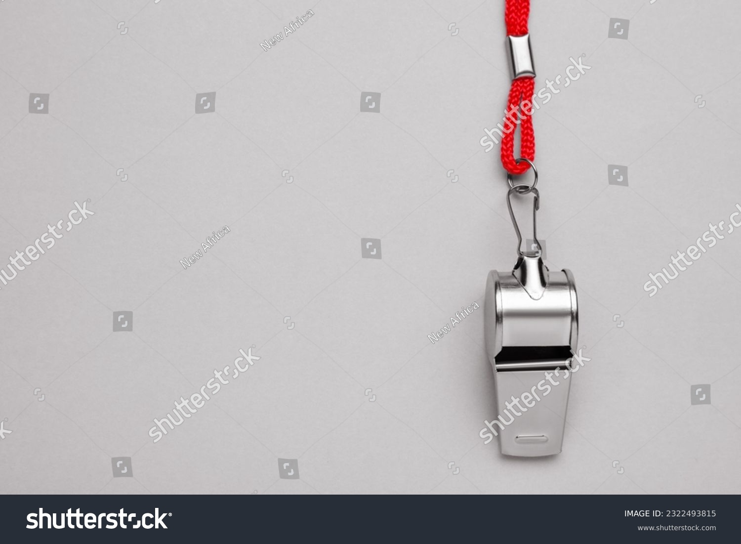 One metal whistle with red cord on light grey background, top view. Space for text #2322493815