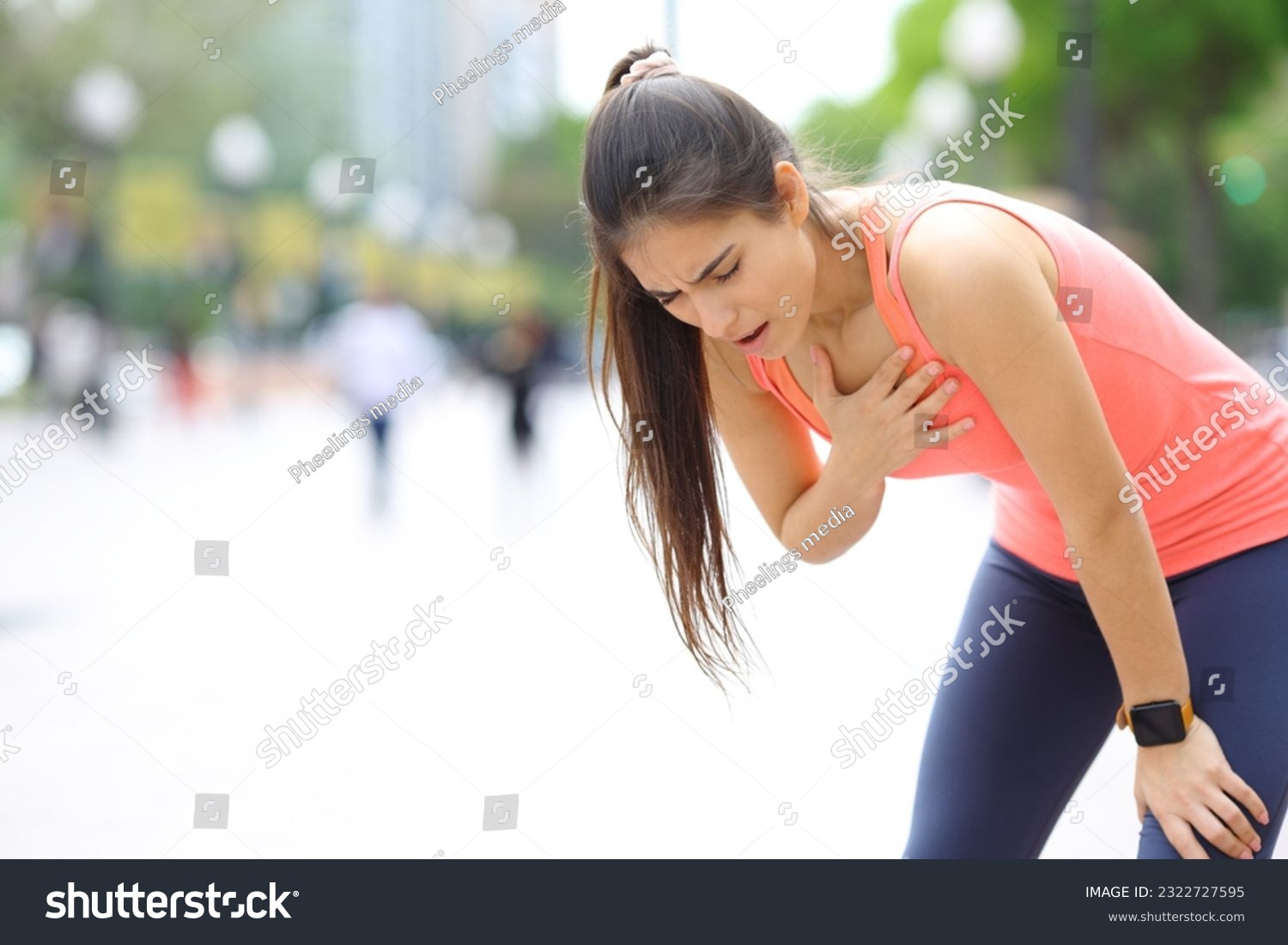 Exhausted runner touching chest breathing in the street #2322727595