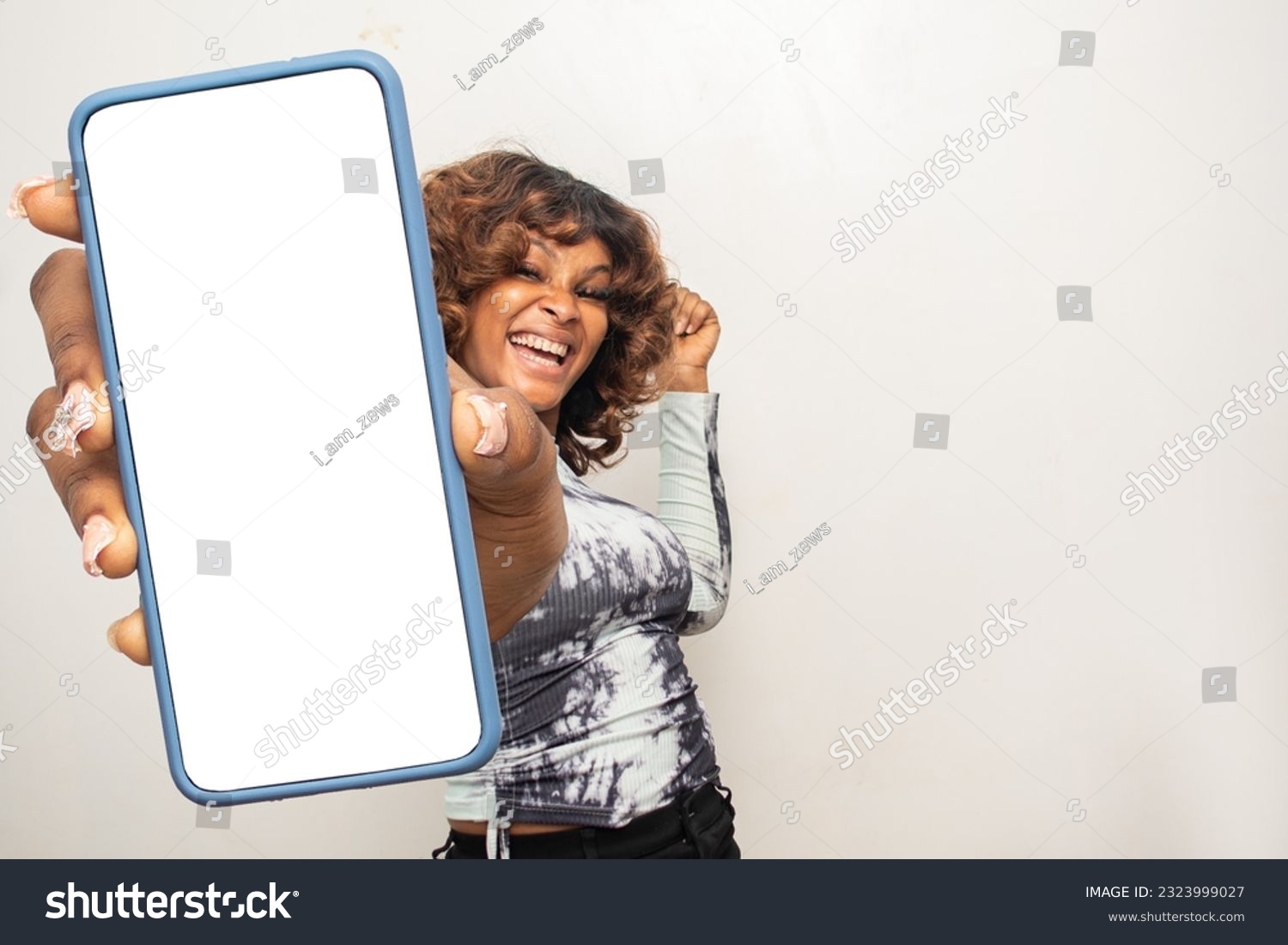 young african woman showing her phone screen excitedly #2323999027