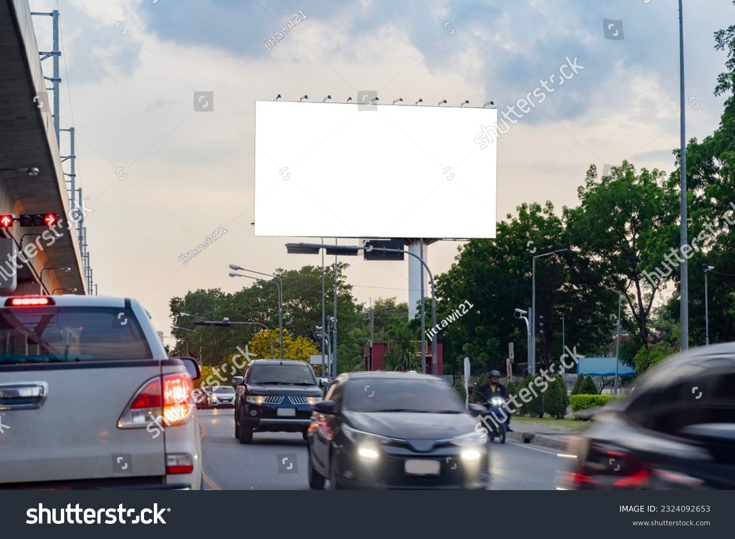 A blank billboard on one of Thailand's streets, a blank billboard with copy space for text or content, mockup of a blank billboard in a big city, evening scene. Space for your ad. #2324092653