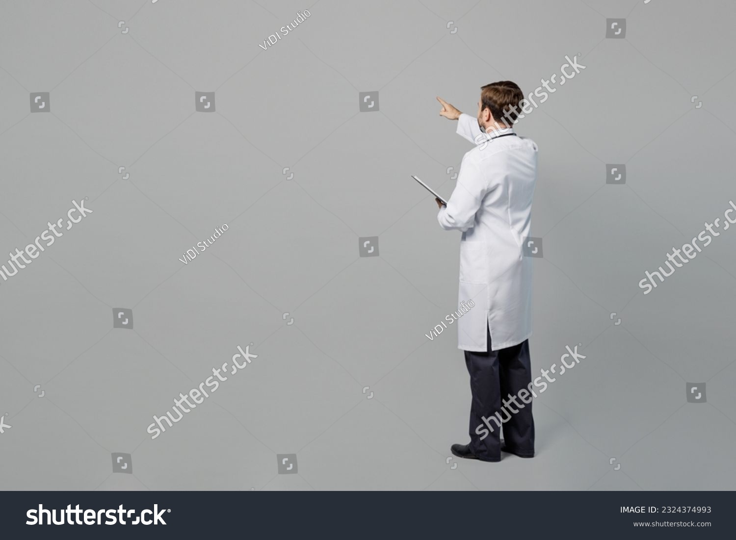 Full size male doctor happy cheerful man wears white medical gown suit work in hospital hold clipboard with paper documents isolated on plain grey color background studio. Healthcare medicine concept #2324374993