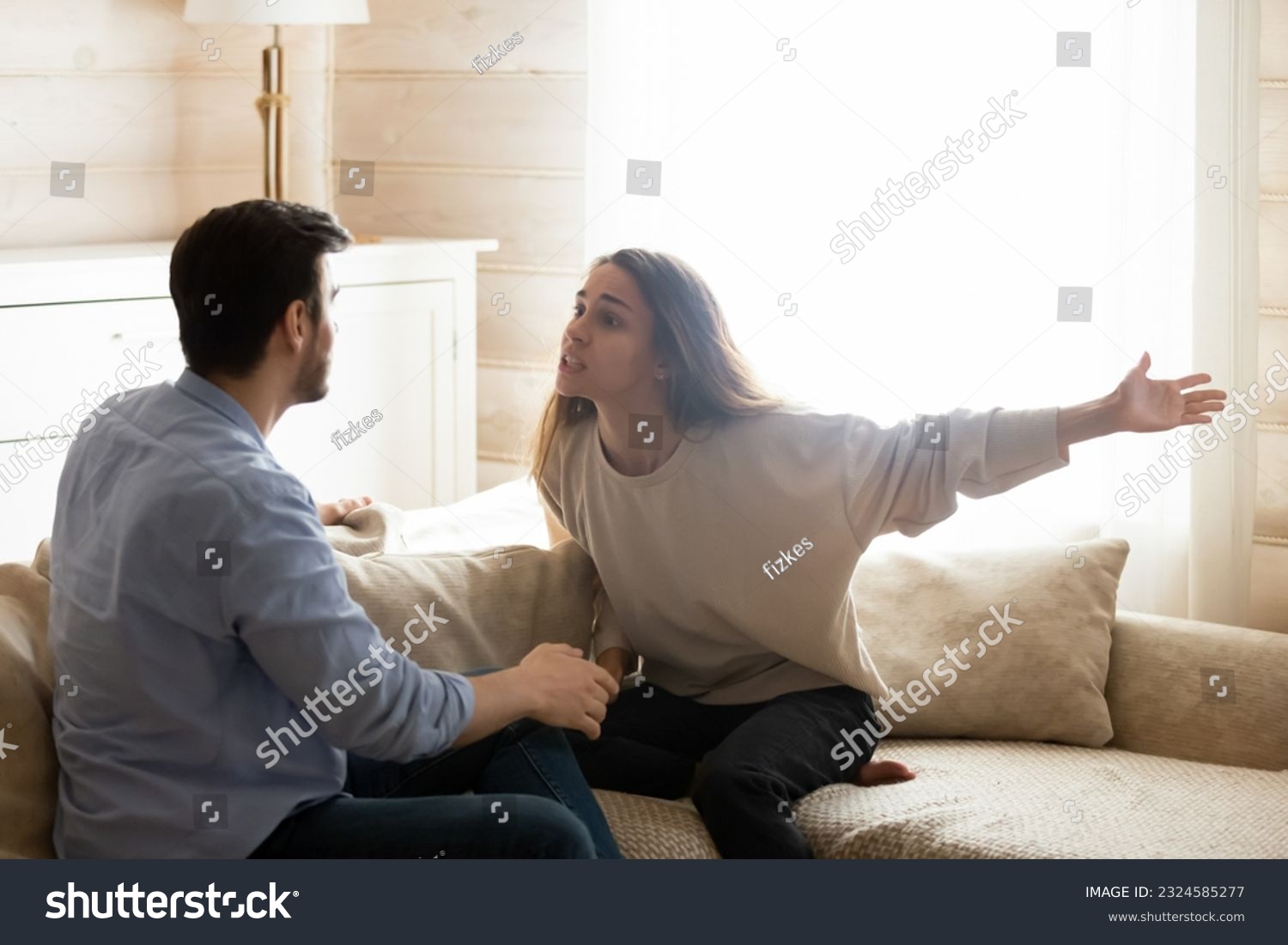 Misunderstanding. Angry worried young spouses quarreling arguing at home, annoyed nervous millennial wife shouting screaming on frustrated husband accusing in cheat threatening with breakup divorce #2324585277