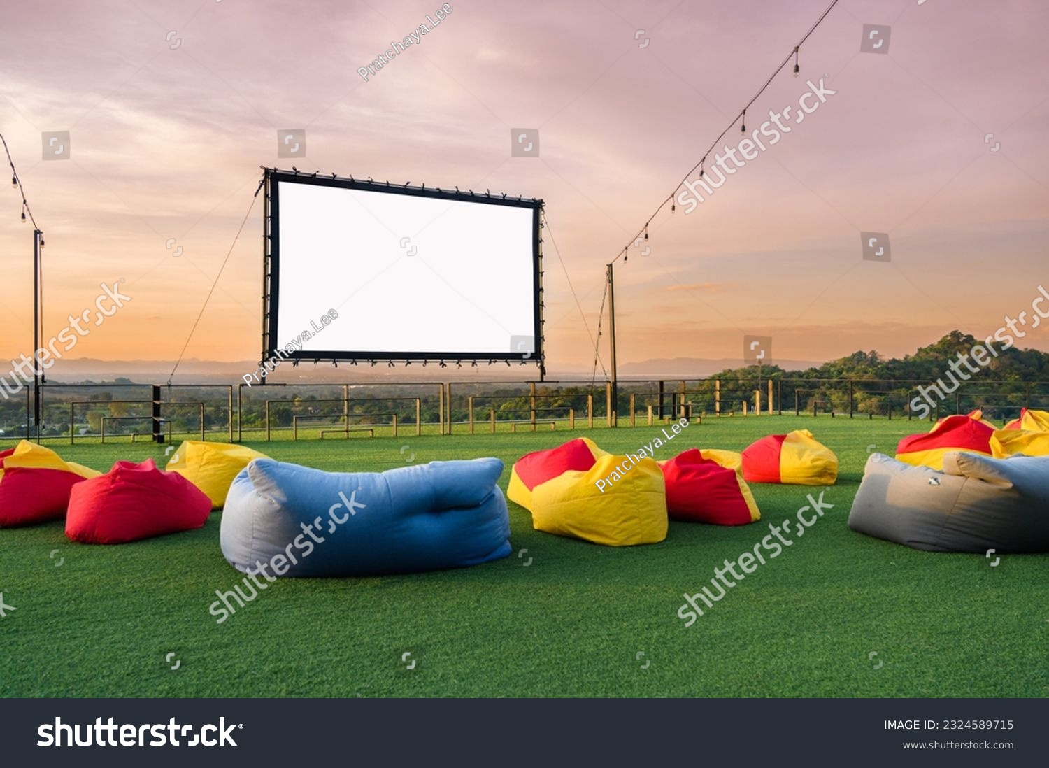 open air cinema with colorful bean bag. empty white screen, free space for text or montage #2324589715