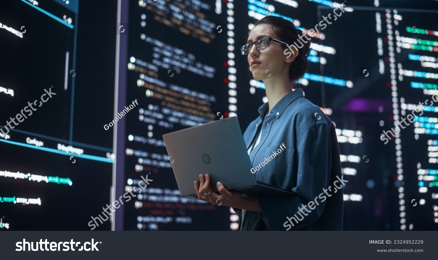 Portrait of Woman Creating a Software and Coding, Surrounded by Big Screens Displaying Lines of Programming Language Code. Female Programmer Working in a Monitoring Room. Futuristic Concept #2324952229