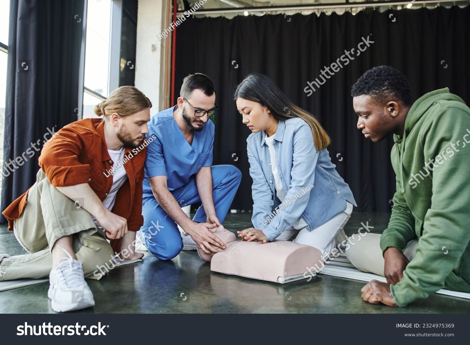 medical seminar, first aid training, cardiopulmonary resuscitation, healthcare worker assisting asian woman practicing chest compressions on CPR manikin near multicultural participants #2324975369