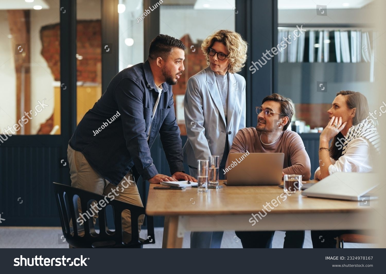 Team of professionals having a meeting in a digital marketing agency. Business people discussing a project in an office. Teamwork and collaboration in a creative workplace. #2324978167