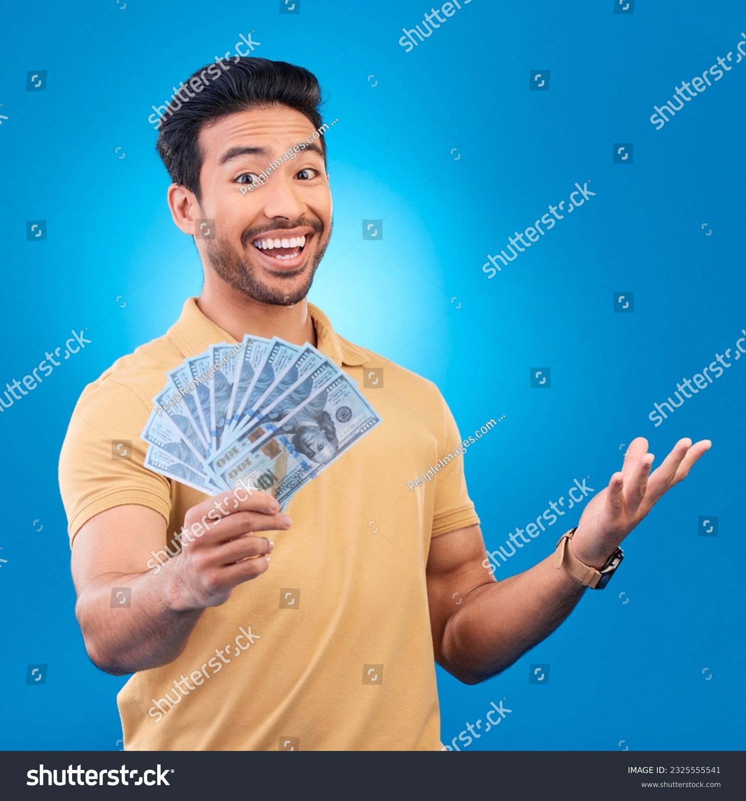 Money, studio and portrait of happy man excited for dollar bills, reward or bonus cash salary, giveaway or prize. Financial freedom, winner or person smile for income, revenue or blue background win #2325555541