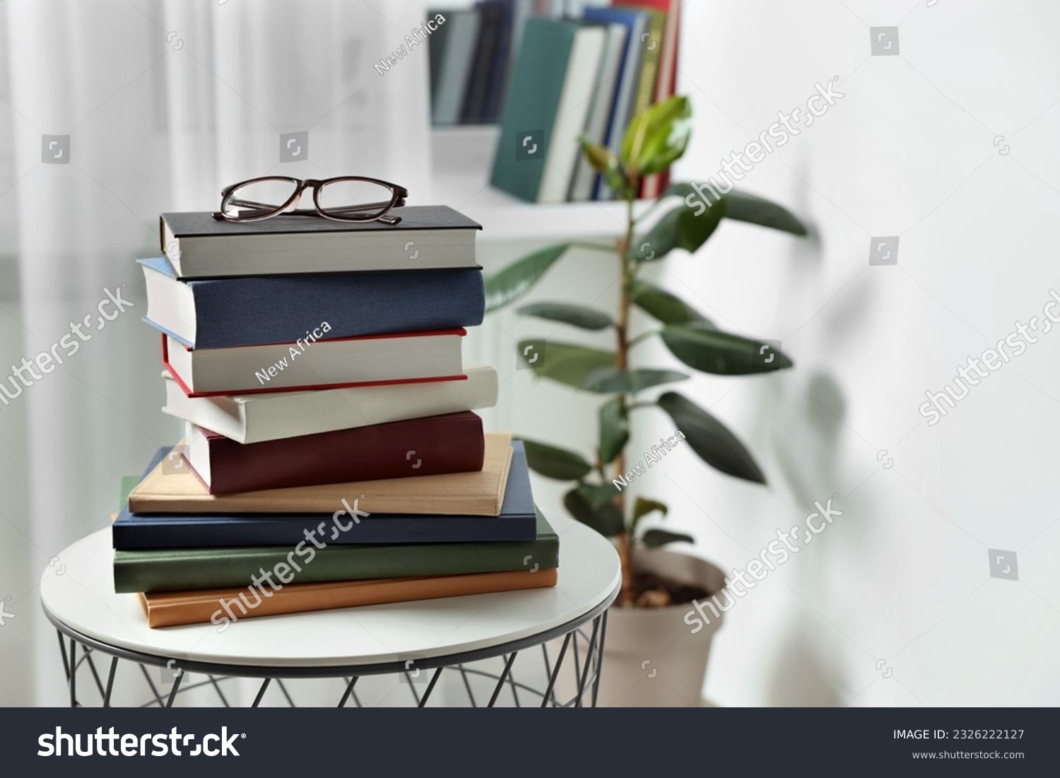 Stack of many different books and glasses on coffee table indoors. Space for text #2326222127