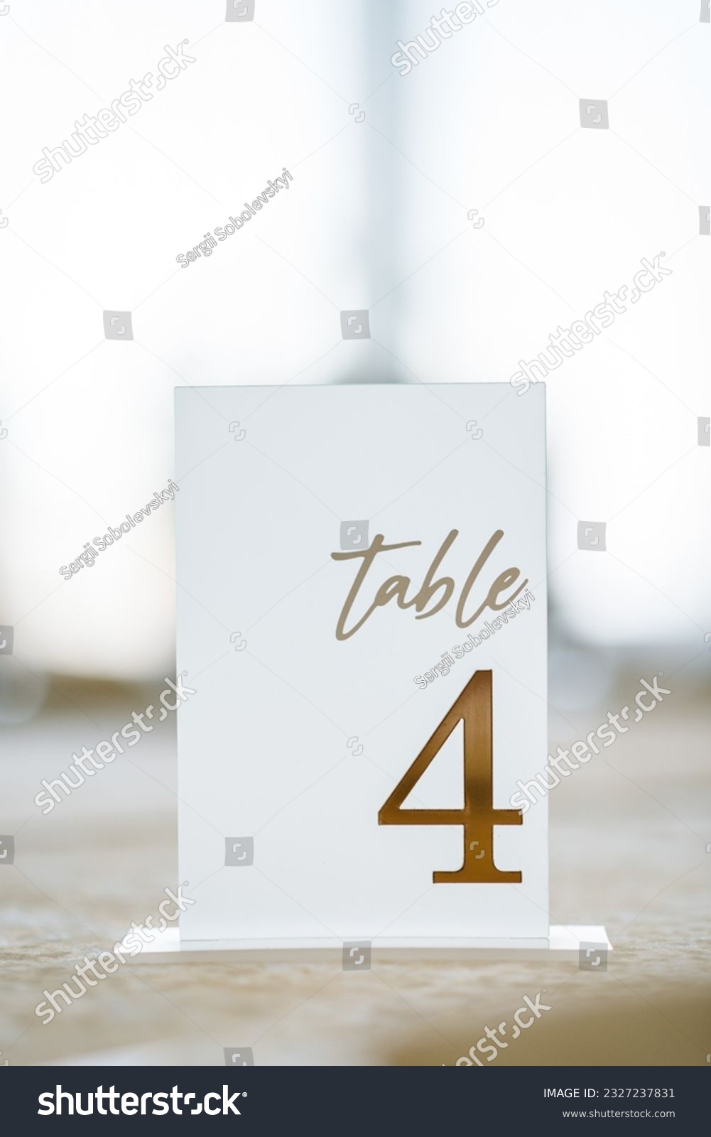 Table number 4. Setting, serving guests closeup. Stands, sign number four. Setup detail. Luxury reception. Elegant detail dinner table. Beautifully organized event. Wedding hall with atmospheric decor #2327237831