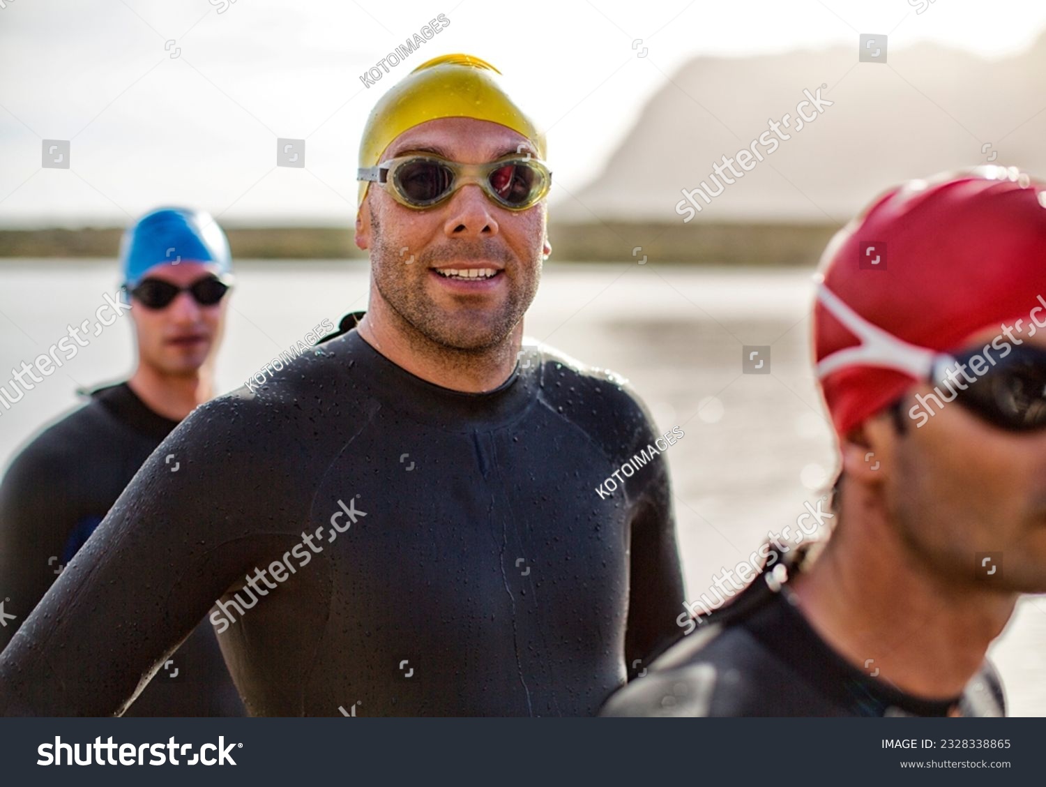 Triathletes in wetsuit smiling in water #2328338865
