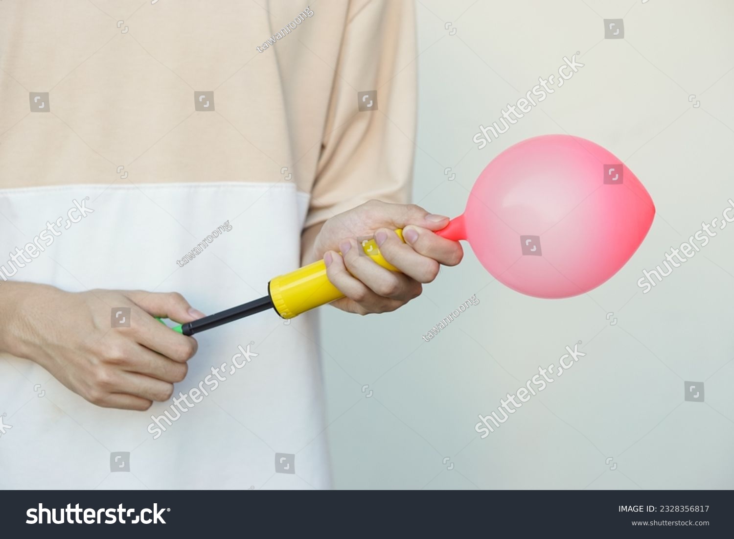 Blowing pink balloon by hand air pump, inflates  air to balloon Concept, children play, toy and equipment to play fun games or prepare party.                                                         #2328356817