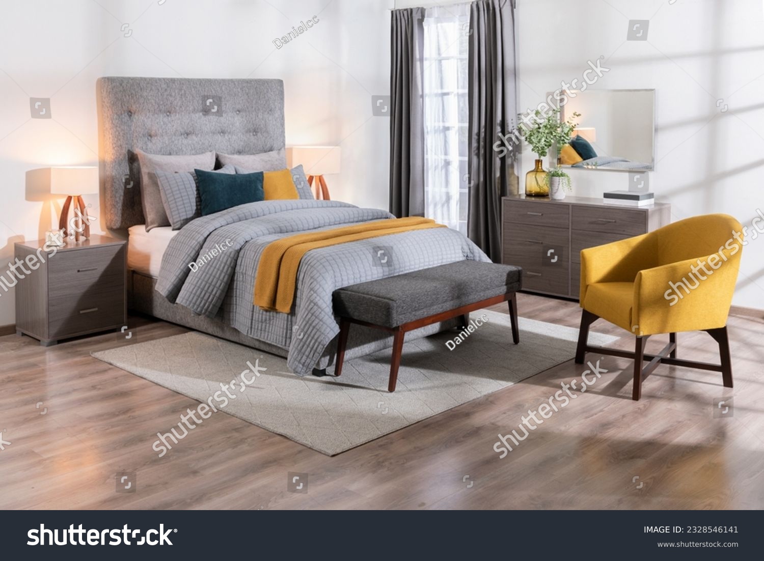 A modern bedroom featuring a large bed, a yellow chair, a dresser, and a wooden bench, a cozy interior space #2328546141