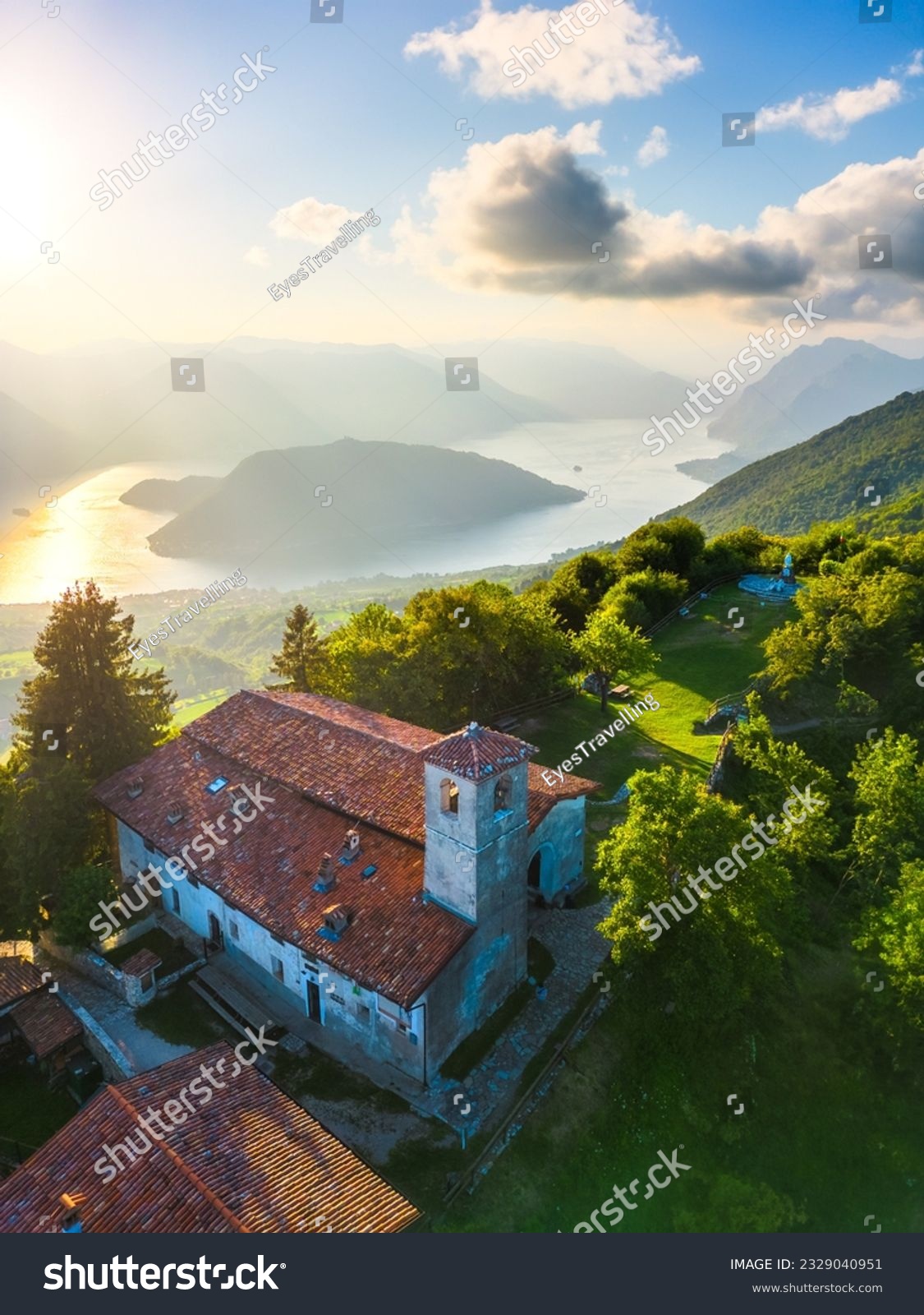 Vertical aerial view of lake Lago d'Iseo and Montisola from Santa Maria del Giogo during summer sunset. Sulzano, Iseo, Lombady, Italy #2329040951