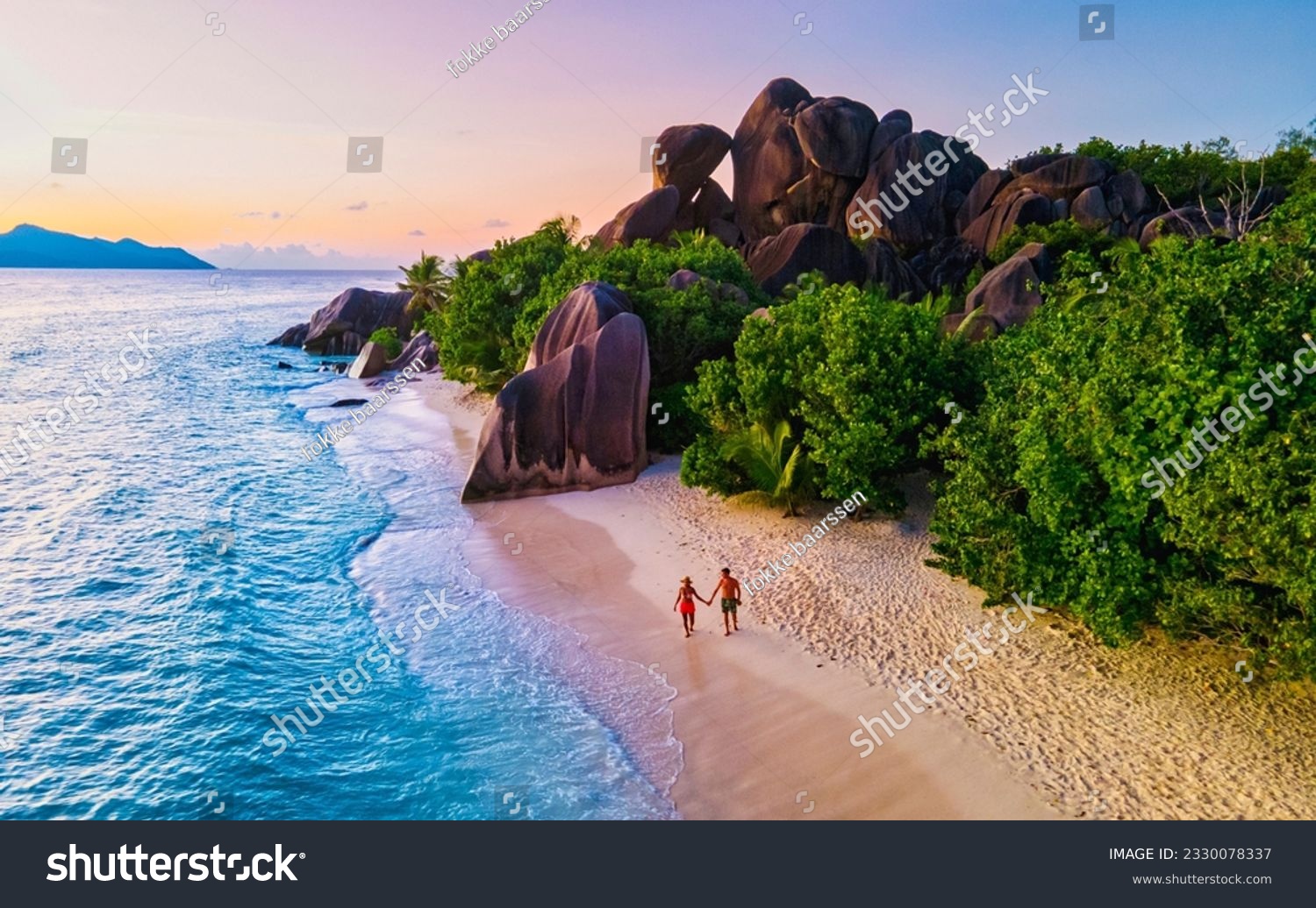 Anse Source d'Argent beach, La Digue Island, Seyshelles, Drone aerial view of La Digue Seychelles bird eye view.of tropical Island, couple men and woman walking at the beach during sunset at a luxury #2330078337