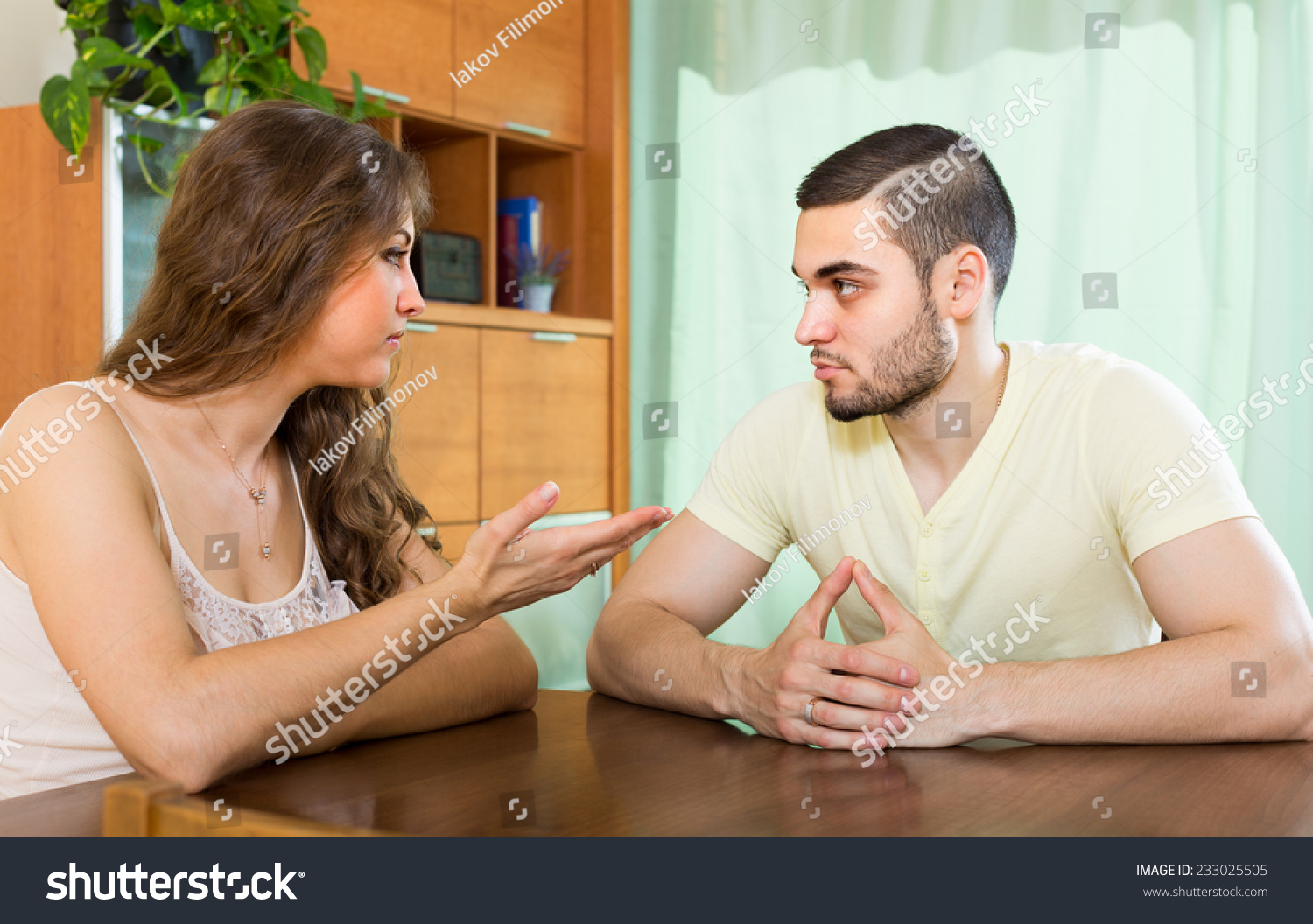 Young family having serious talking at the table in home #233025505