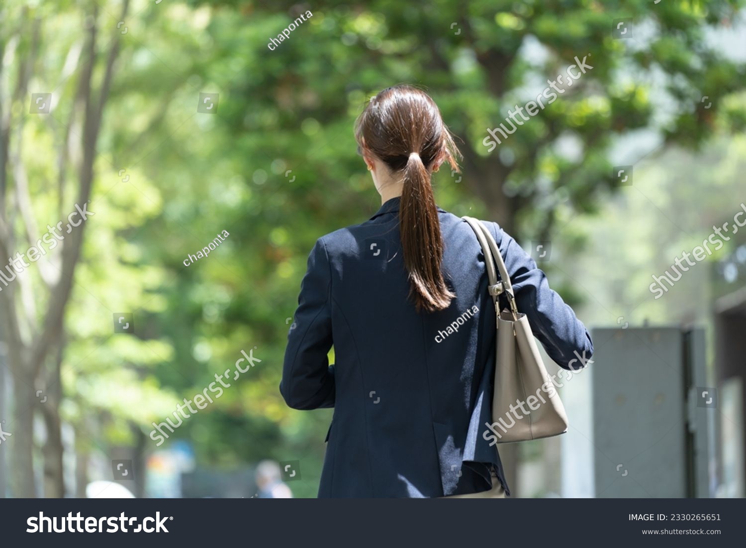 A Japanese woman in a suit standing in the fresh green #2330265651